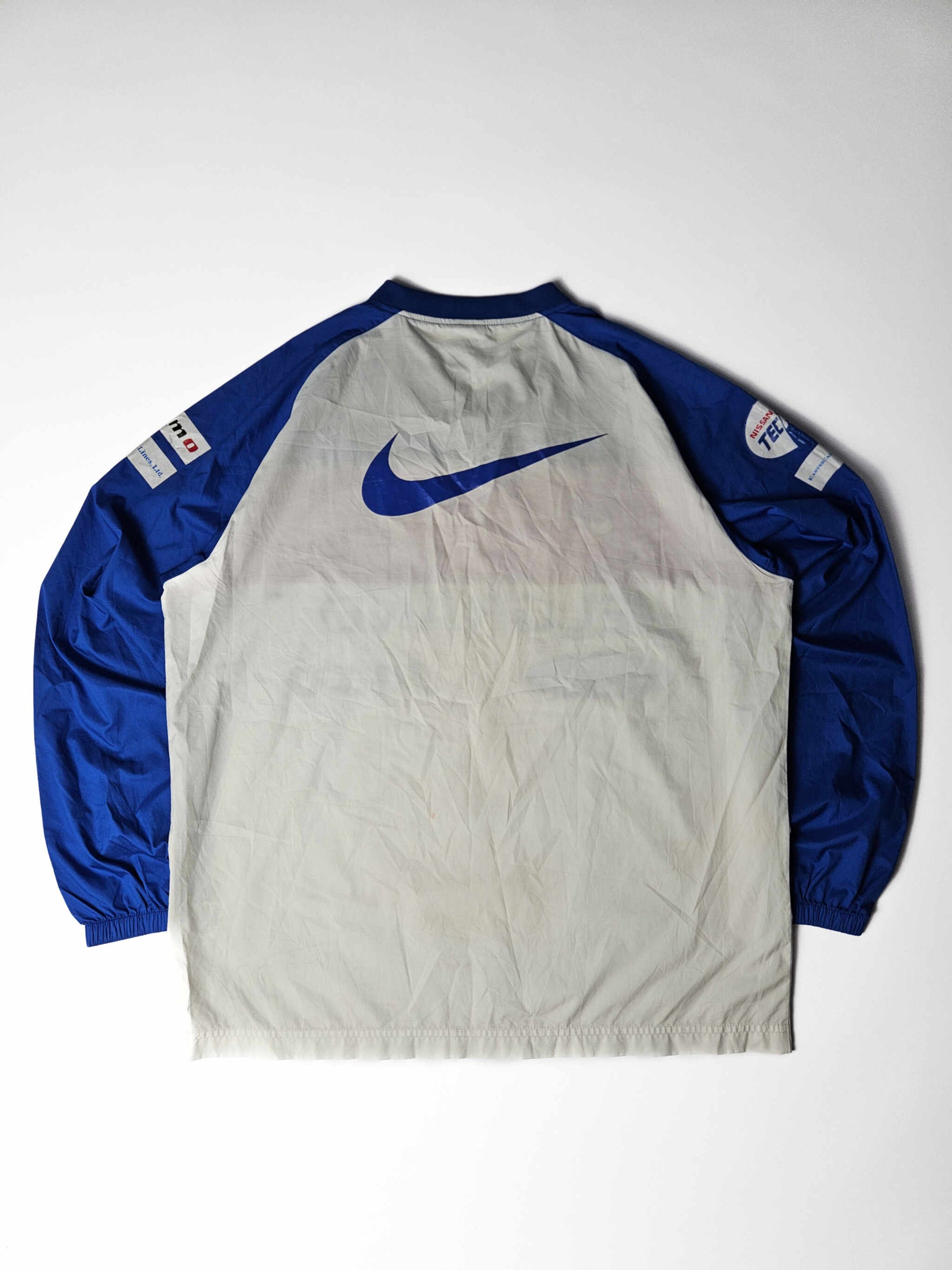 Achterzijde van een authentiek 2000s vintage Yokohama F. Marinos Nike voetbalshirt – grote blauwe Nike swoosh en originele gesponsorde mouwen, populair bij J-League verzamelaars