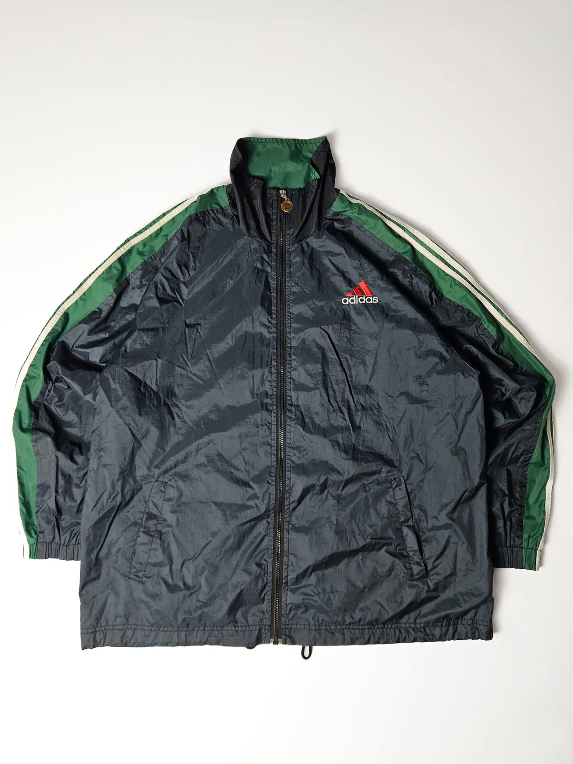 Originele jaren 90 Adidas France 98 World Cup vintage windbreaker – zwart met groene en witte strepen, geborduurd rood Adidas-logo en relaxte oversized fit, geliefd bij voetbal- en streetwear verzamelaars