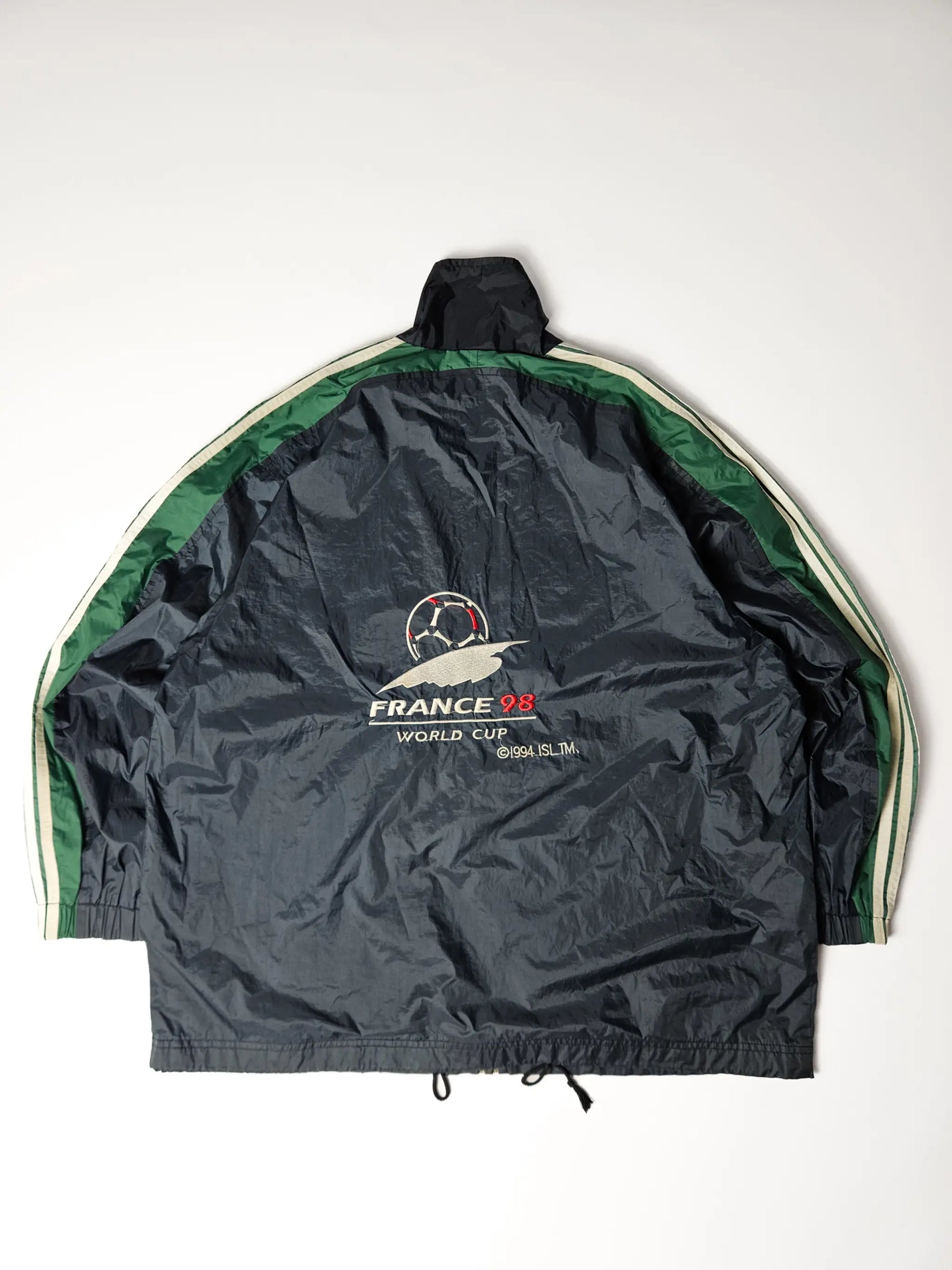Achterzijde van een authentieke Adidas France 98 World Cup windbreaker – groot geborduurd logo met voetbal en France 98 tekst, iconisch jaren 90 sportdesign voor voetbalfans en vintage collectors