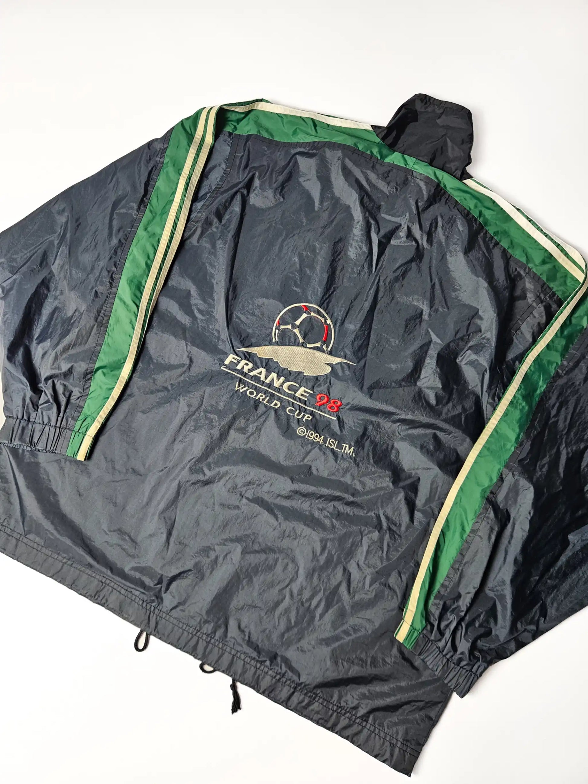 Achterzijde van een authentieke Adidas France 98 World Cup windbreaker – groot geborduurd logo met voetbal en France 98 tekst, iconisch jaren 90 sportdesign voor voetbalfans en vintage collectors