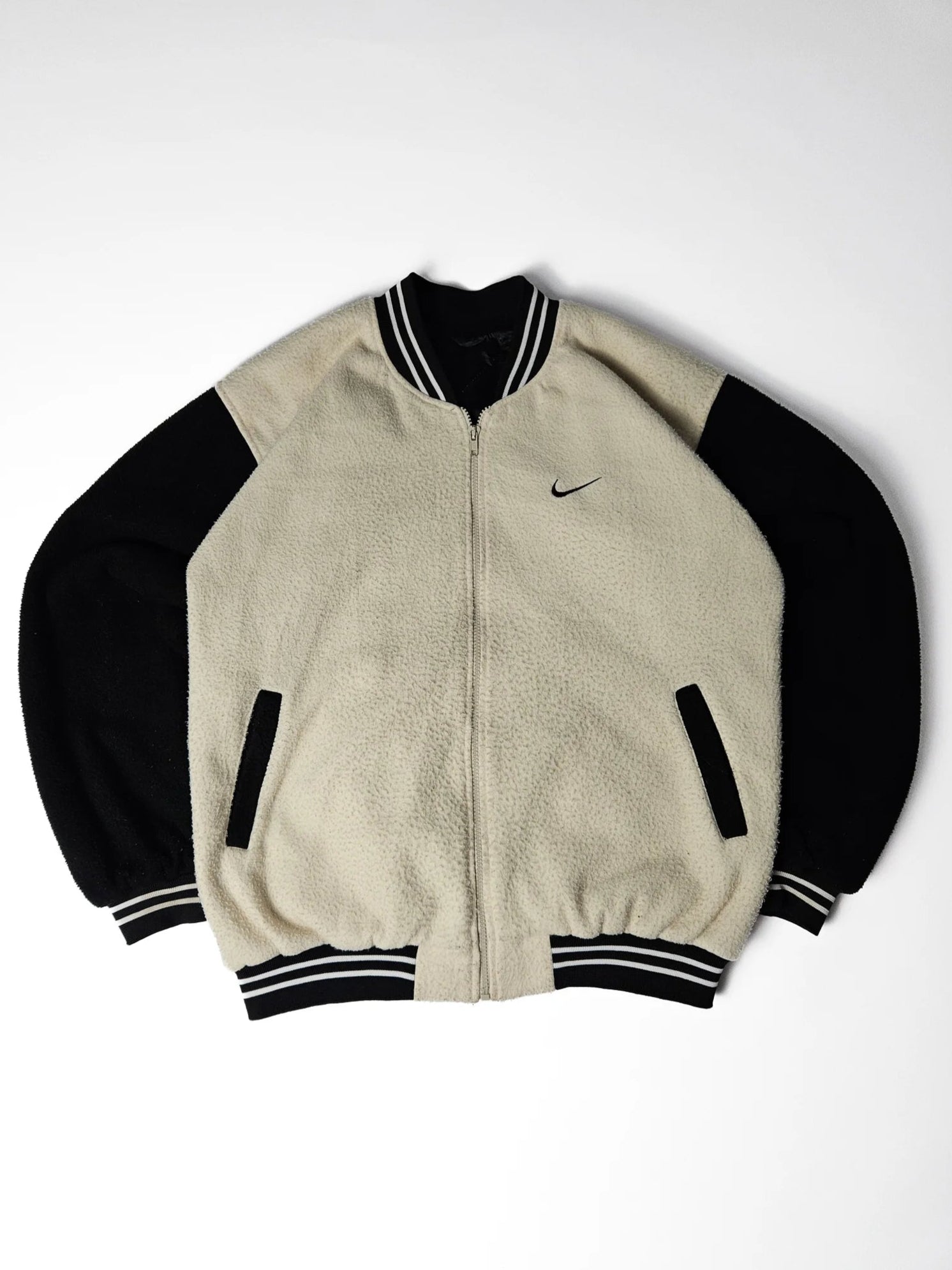 Zwart-beige Nike fleece varsity jacket met geborduurd kleine Nike swoosh op de borst – relaxed fit jaren 90 streetwear en sportstyle collectors item
