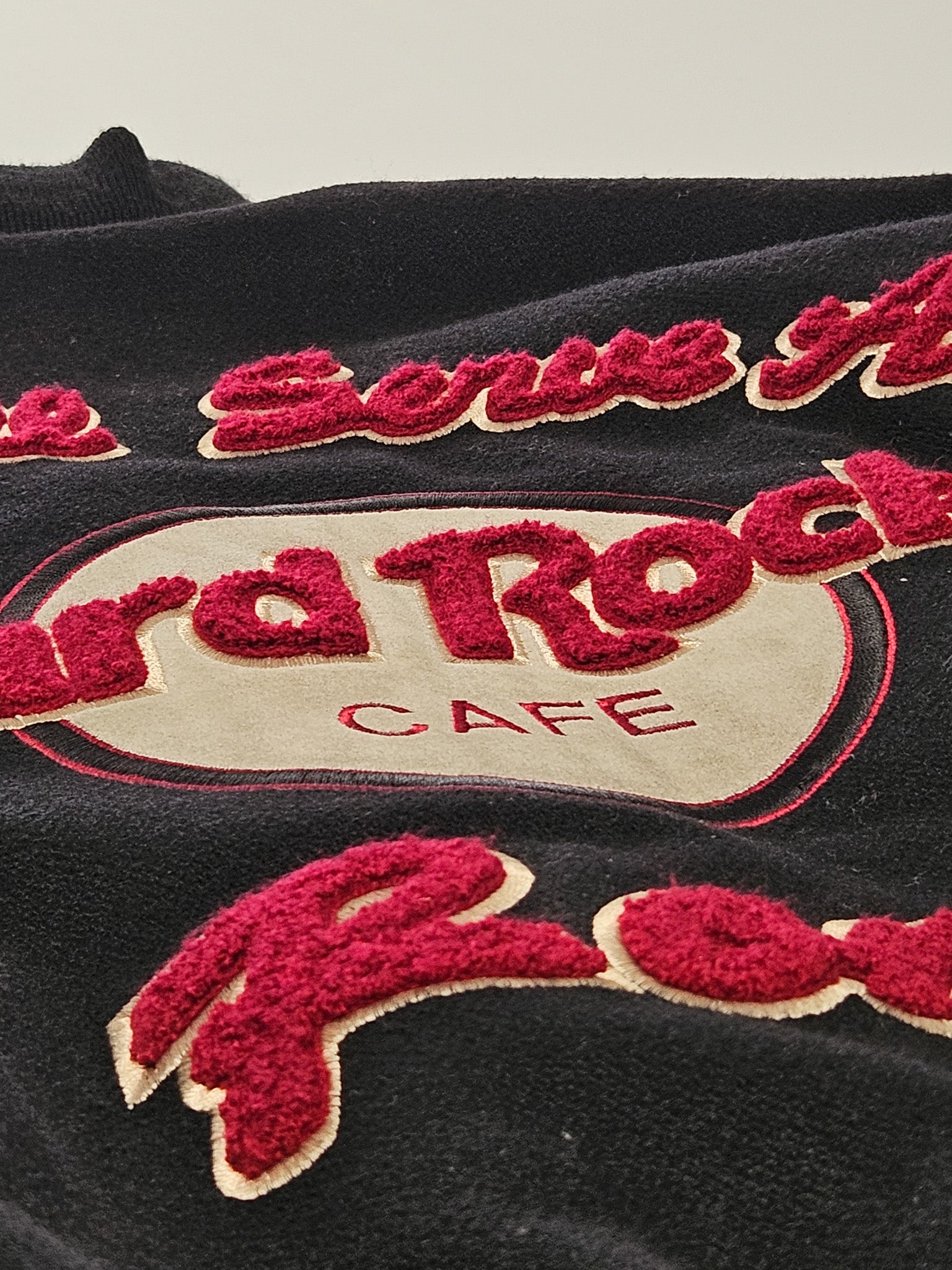 Detail van het geborduurde Hard Rock Rome logo op de rug van de vintage varsity jas