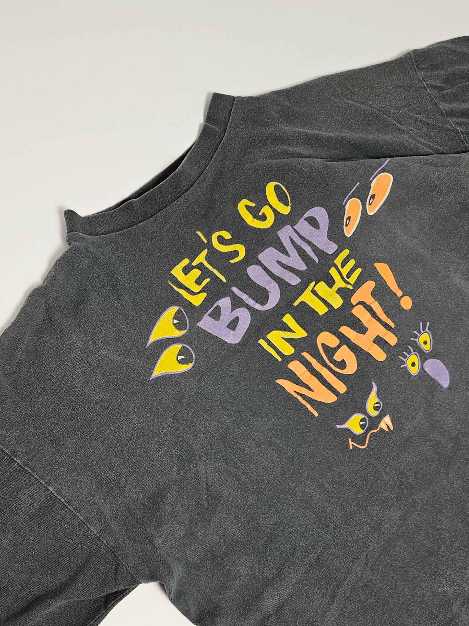 Detail van de "Let's Go Bump in the Night" Halloween-print op vintage T-shirt