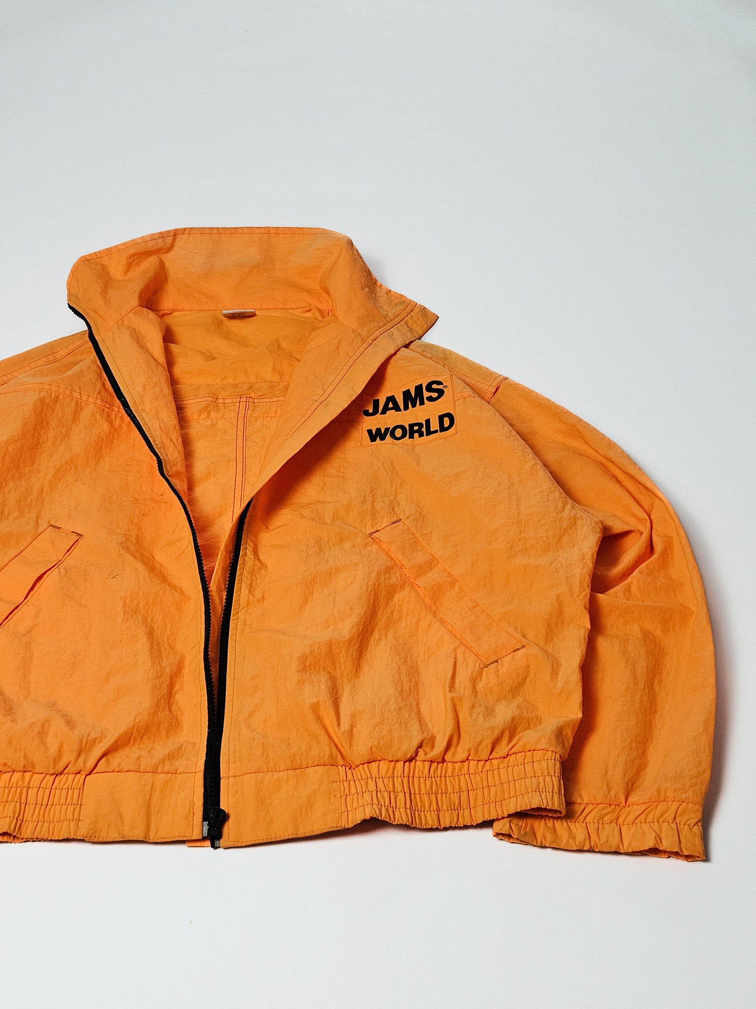 Half geopende Jams World windbreaker met zicht op binnenvoering en borstprint