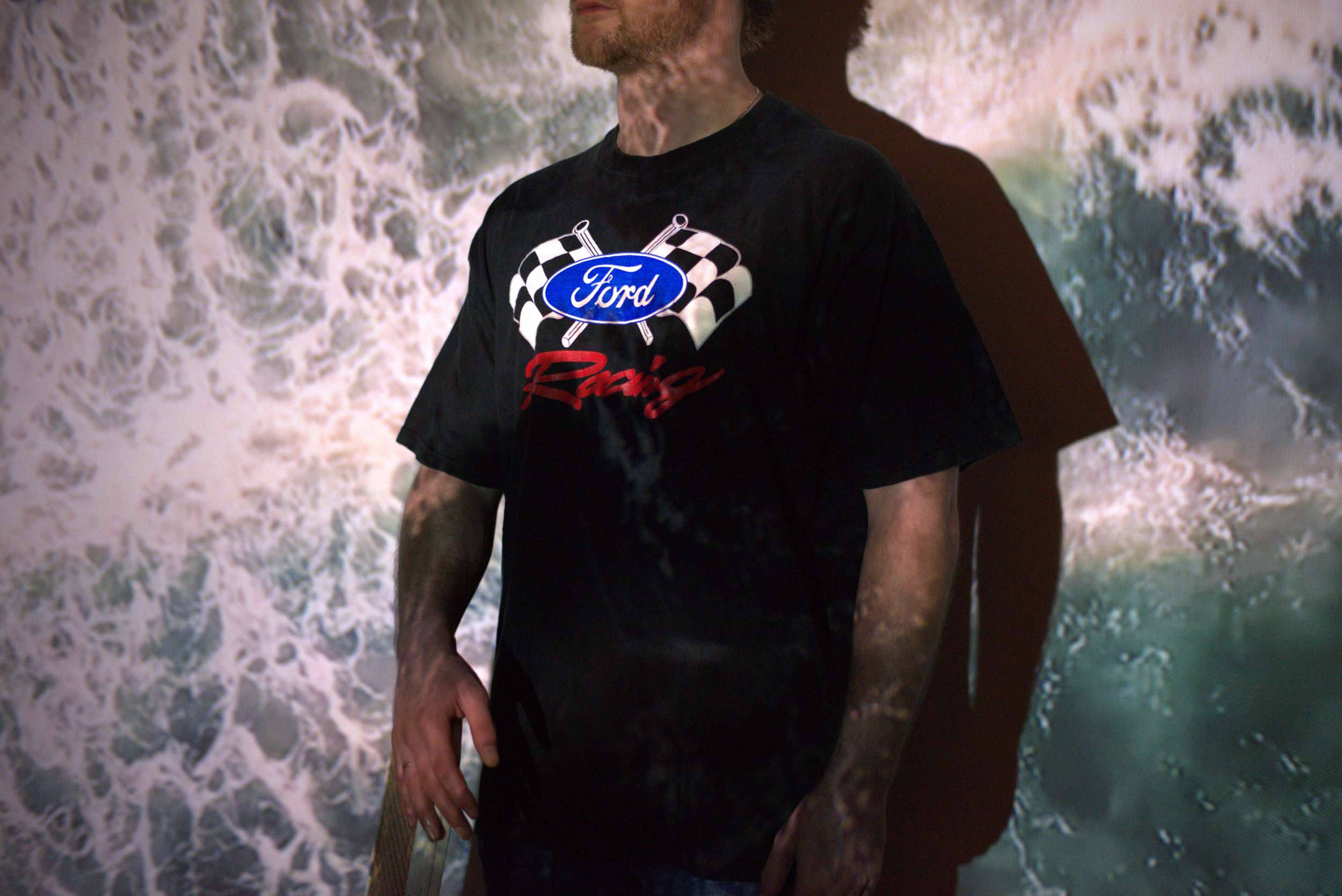Model draagt een oversized vintage T-shirt met kleurrijke cartoonprint uit de jaren '90, gefotografeerd tegen een witte achtergrond – Slow Fashion Vintage collectie.