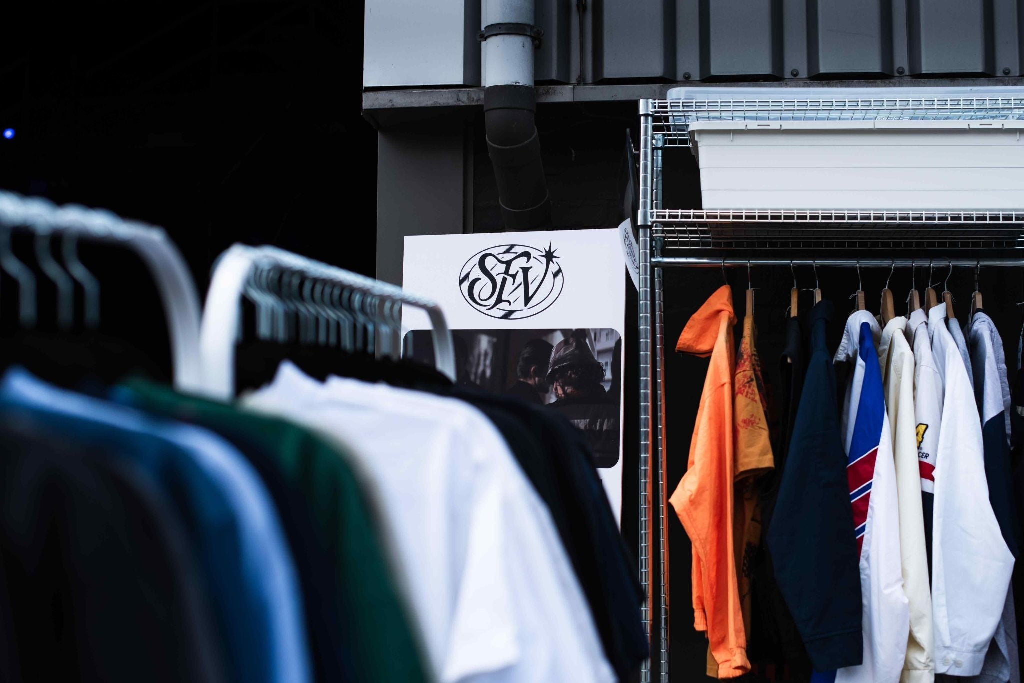 Flatlay van een kleurrijke collectie vintage T-shirts, sweatshirts en jacks uit de jaren '80 en '90, met prints van o.a. Hard Rock Café, NFL, stripfiguren, bandshirts en tie-dye – Slow Fashion Vintage selectie.