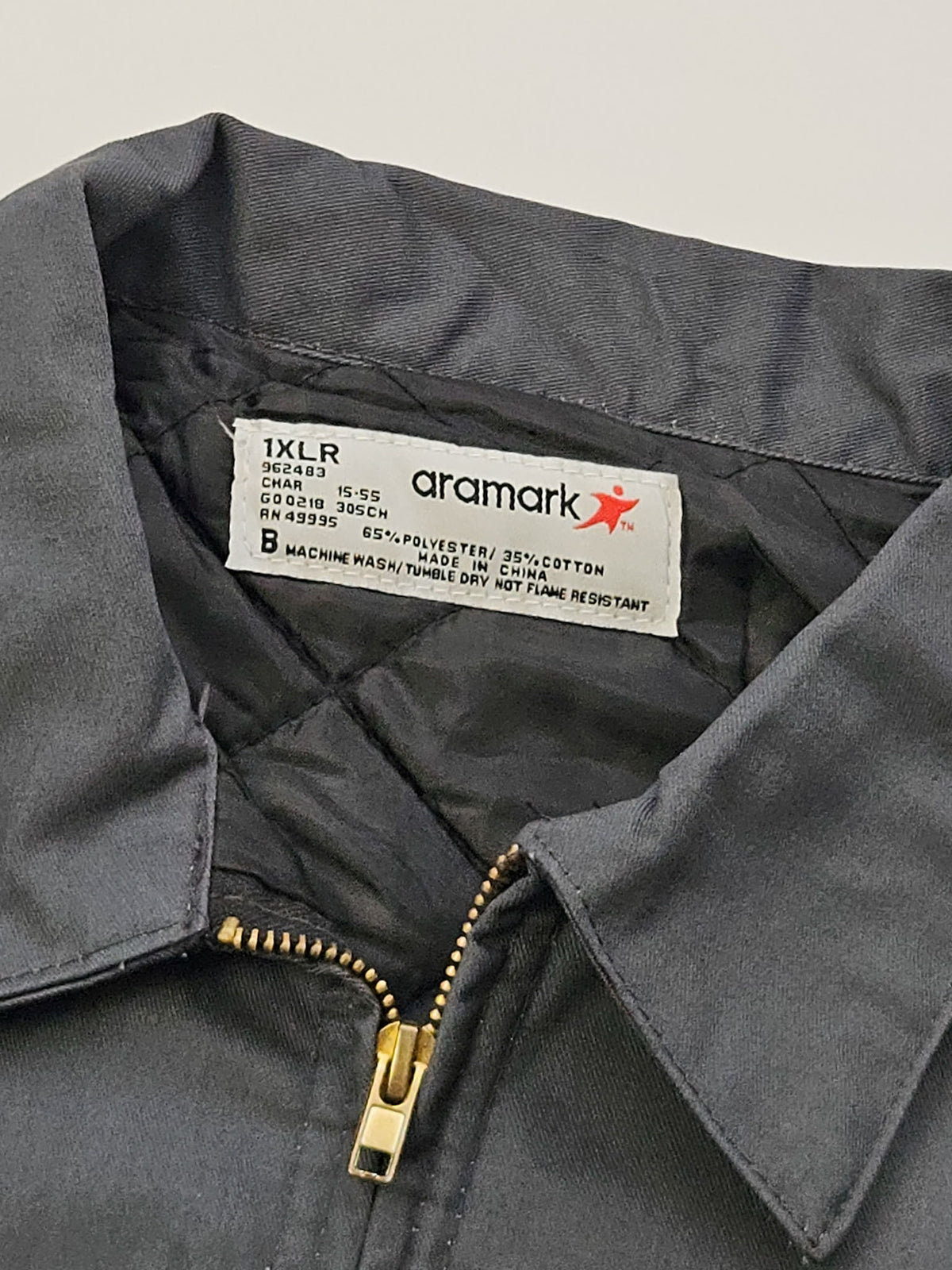 Aramark-label in vintage work jacket, maat 1XLR en 65% polyester met 35% katoen, made in China.
