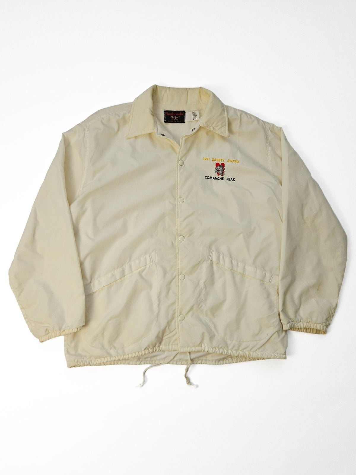 Crème vintage coachjack plat gefotografeerd, met lange mouwen, elastische manchetten en een trekkoord in de zoom.
