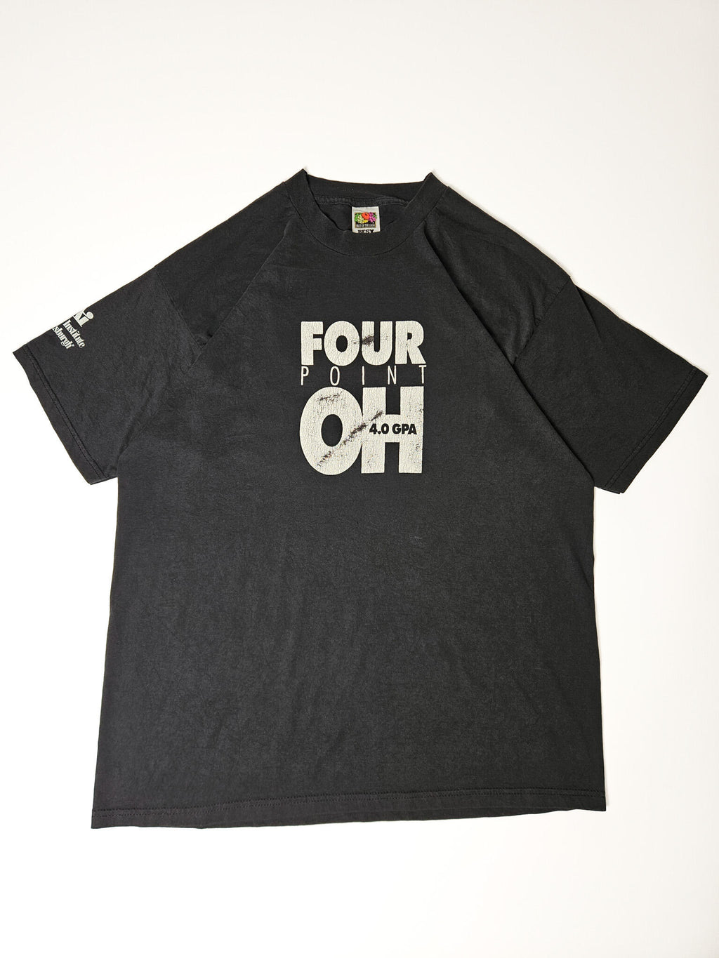 "Volledige weergave van een zwart vintage T-shirt, plat gelegd. Het T-shirt toont de witte 'FOUR POINT OH 4.0 GPA' print op de borst en het 'The Art Institute of Pittsburgh' logo op de mouw. Dit casual en authentieke kledingstuk is een duurzame keuze voor liefhebbers van slow fashion."

