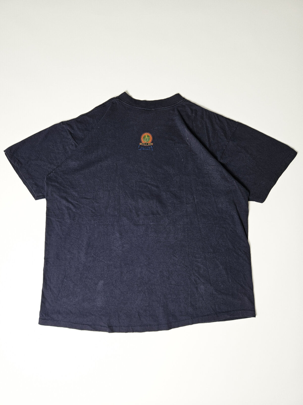 Achterzijde van vintage Bugle Boy T-shirt met kleine kleurrijke logo-opdruk onder de kraag – minimalistisch en typerend voor authentieke jaren 90 casual wear