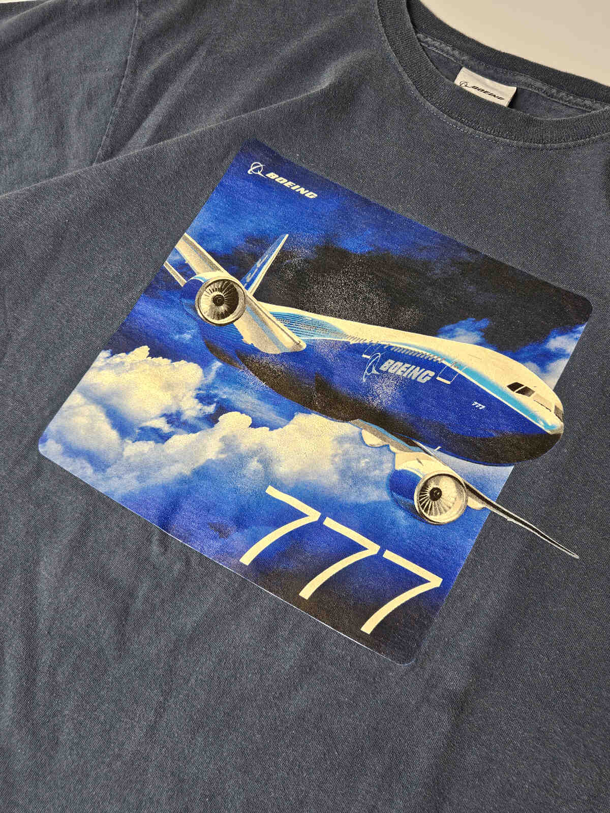 Close-up van Boeing 777 grafische opdruk met natuurlijke craquelé en vintage patina – duidelijke jaren 90 plastisol-print, ideaal voor echte Boeing en vliegtuighistorie verzamelaars