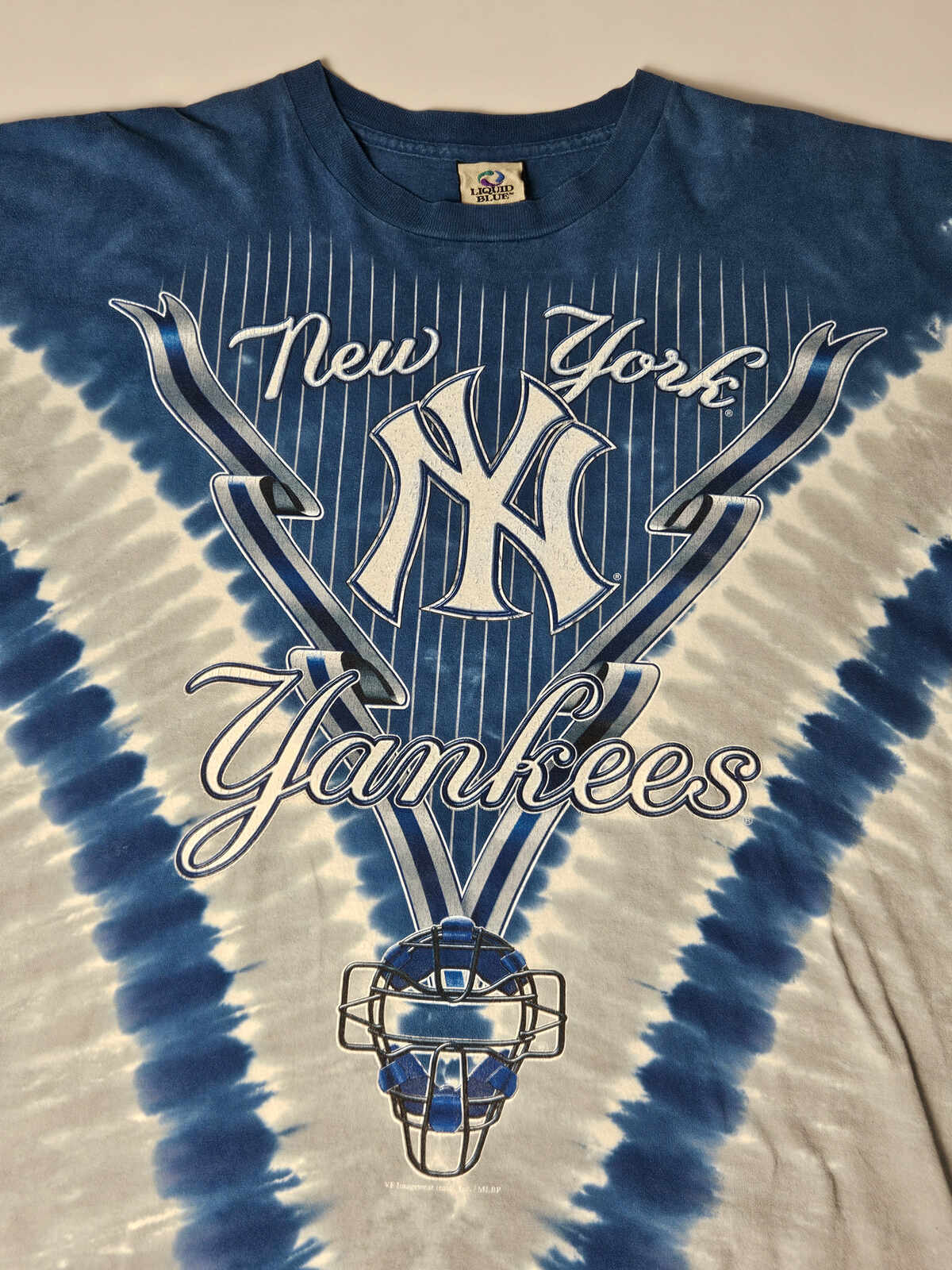 "New York Yankees vintage T-shirt met tie-dye en pinstripe design – Liquid Blue productie, klassieke 90s MLB streetwear vibe"

