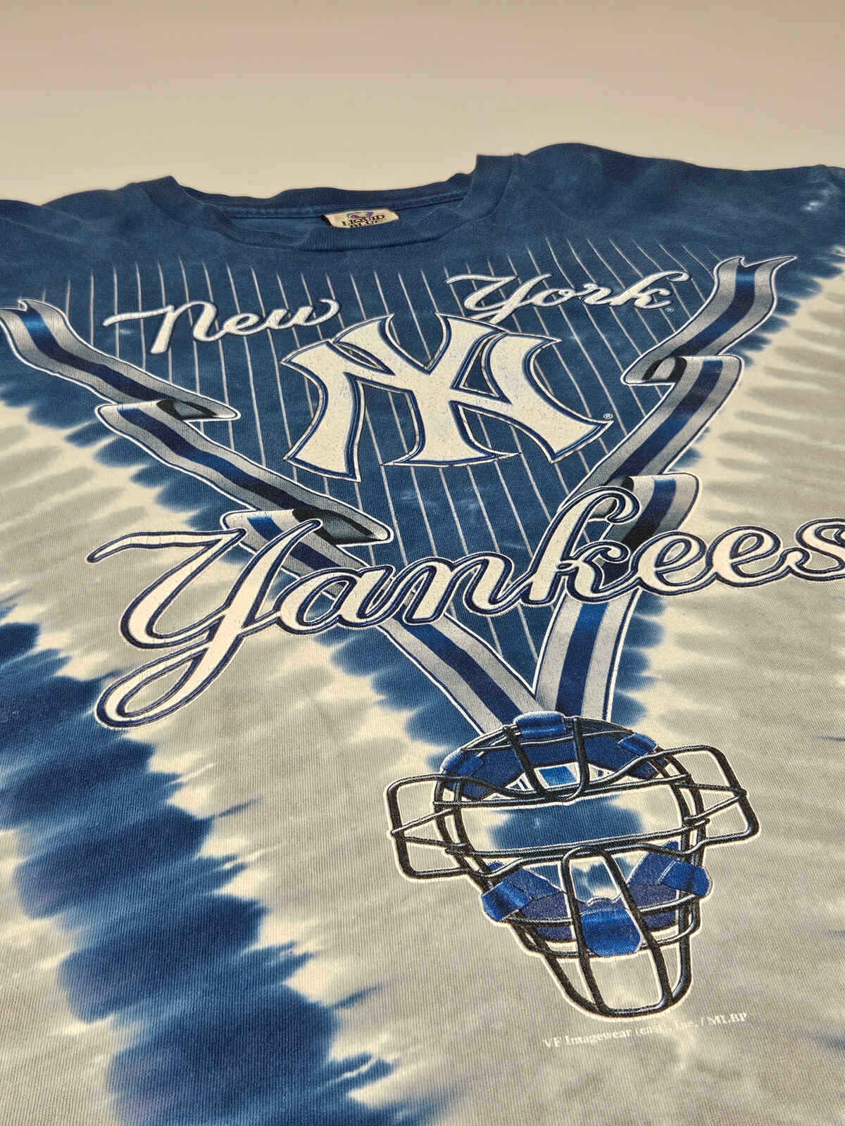 "Vintage New York Yankees T-shirt met opvallende blauwe en grijze tie-dye V-print en authentiek MLB logo – echte 90s baseball fanwear"

