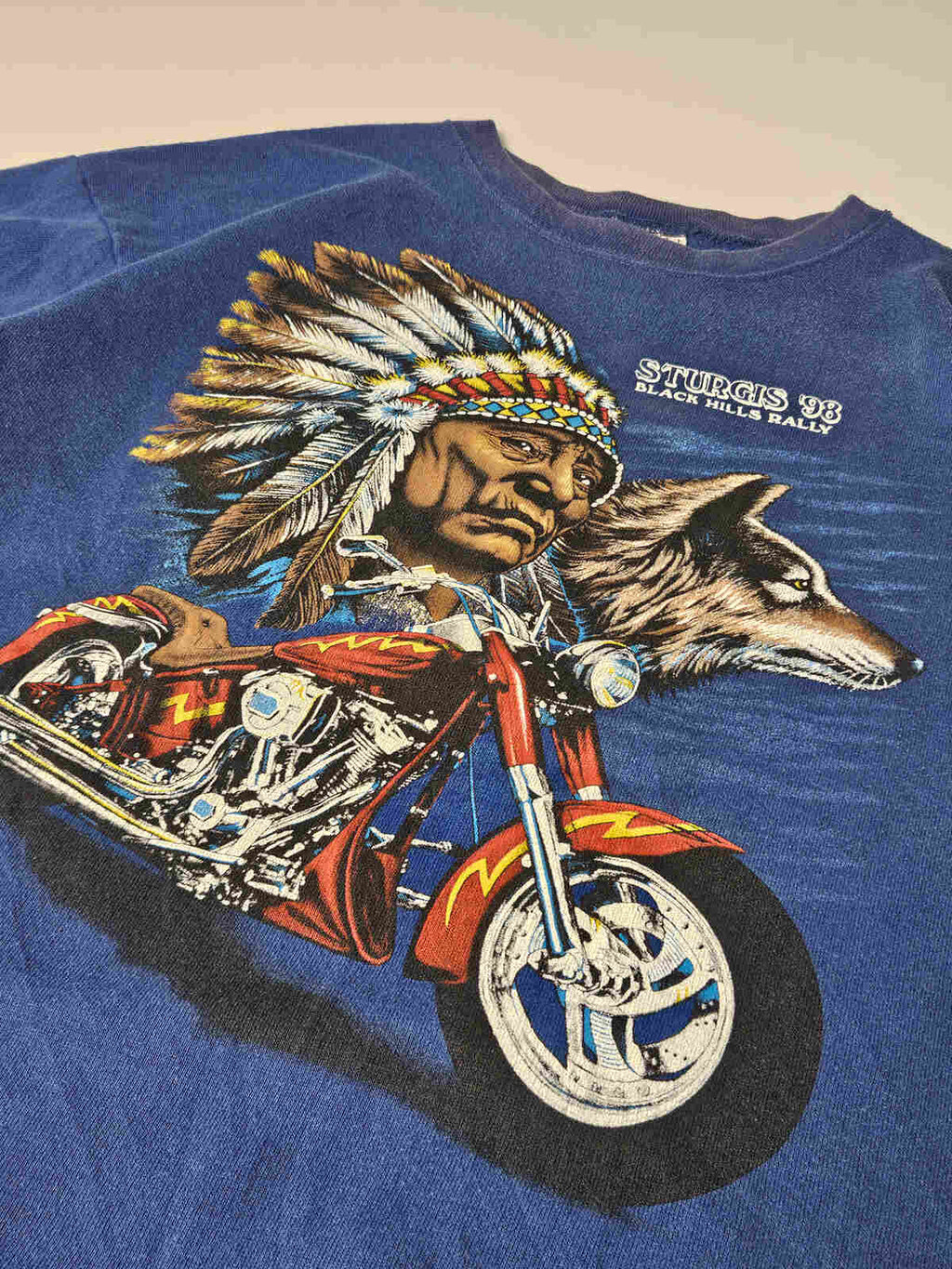 "Close-up van Sturgis '98 motor graphic met Native American chief en wolf – originele jaren 90 screen printed biker graphic"

