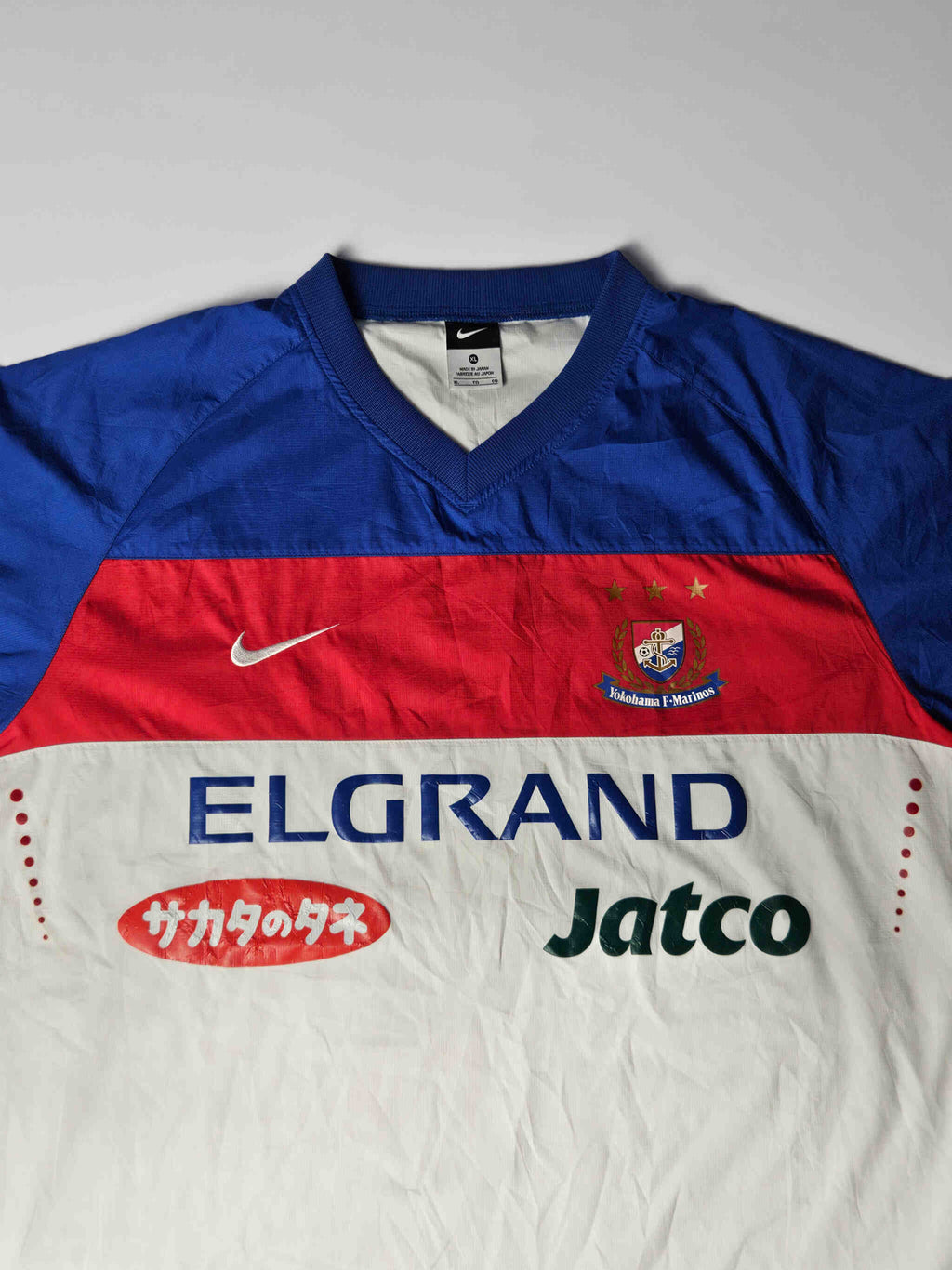 Yokohama F. Marinos clublogo met drie gouden sterren en originele geborduurde details – kenmerkend voor J-League Nike voetbalshirts uit de vroege jaren 2000, geliefd onder Japanse voetbal fans

