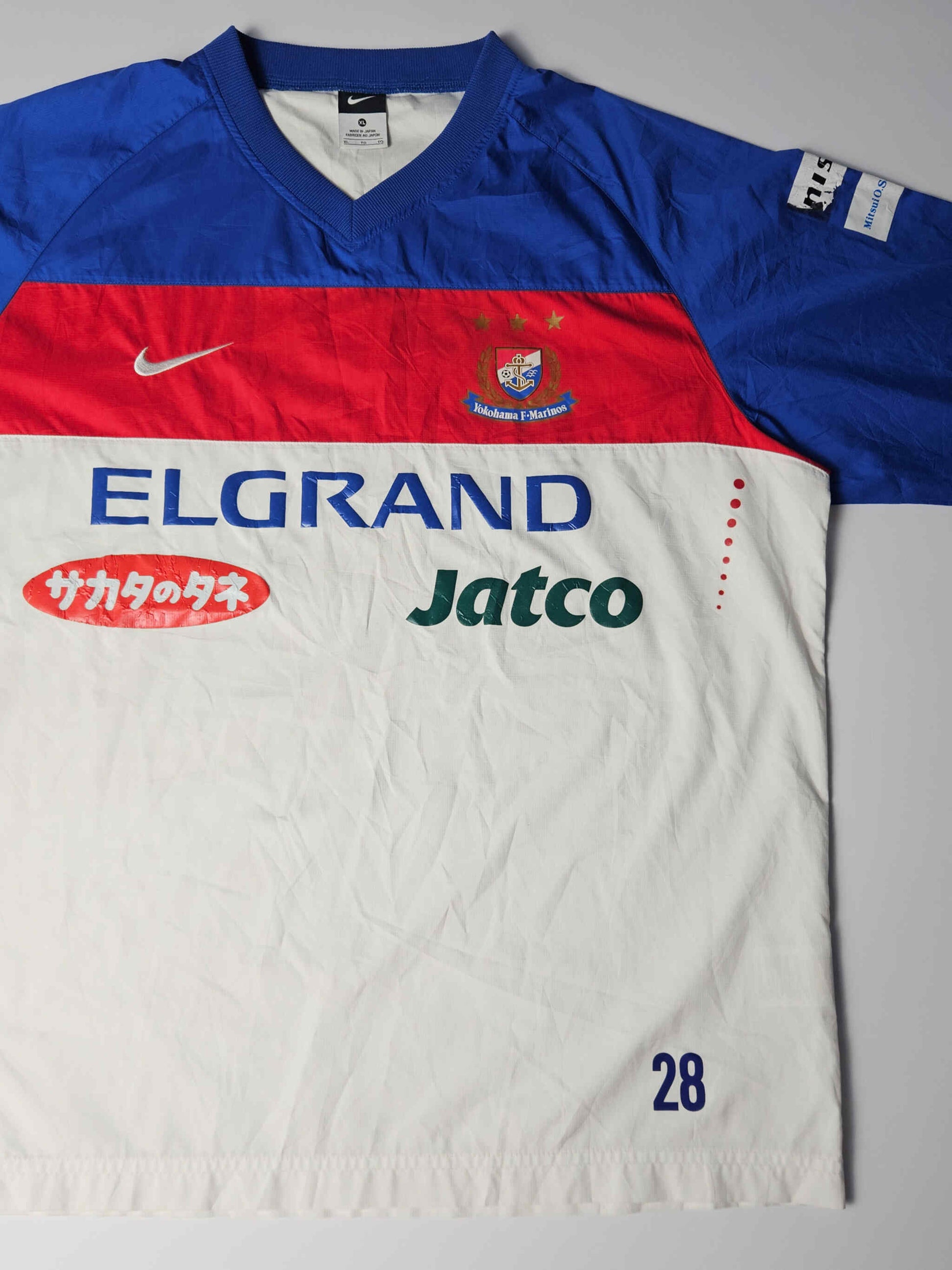 Yokohama F. Marinos clublogo met drie gouden sterren en originele geborduurde details – kenmerkend voor J-League Nike voetbalshirts uit de vroege jaren 2000, geliefd onder Japanse voetbal fans

