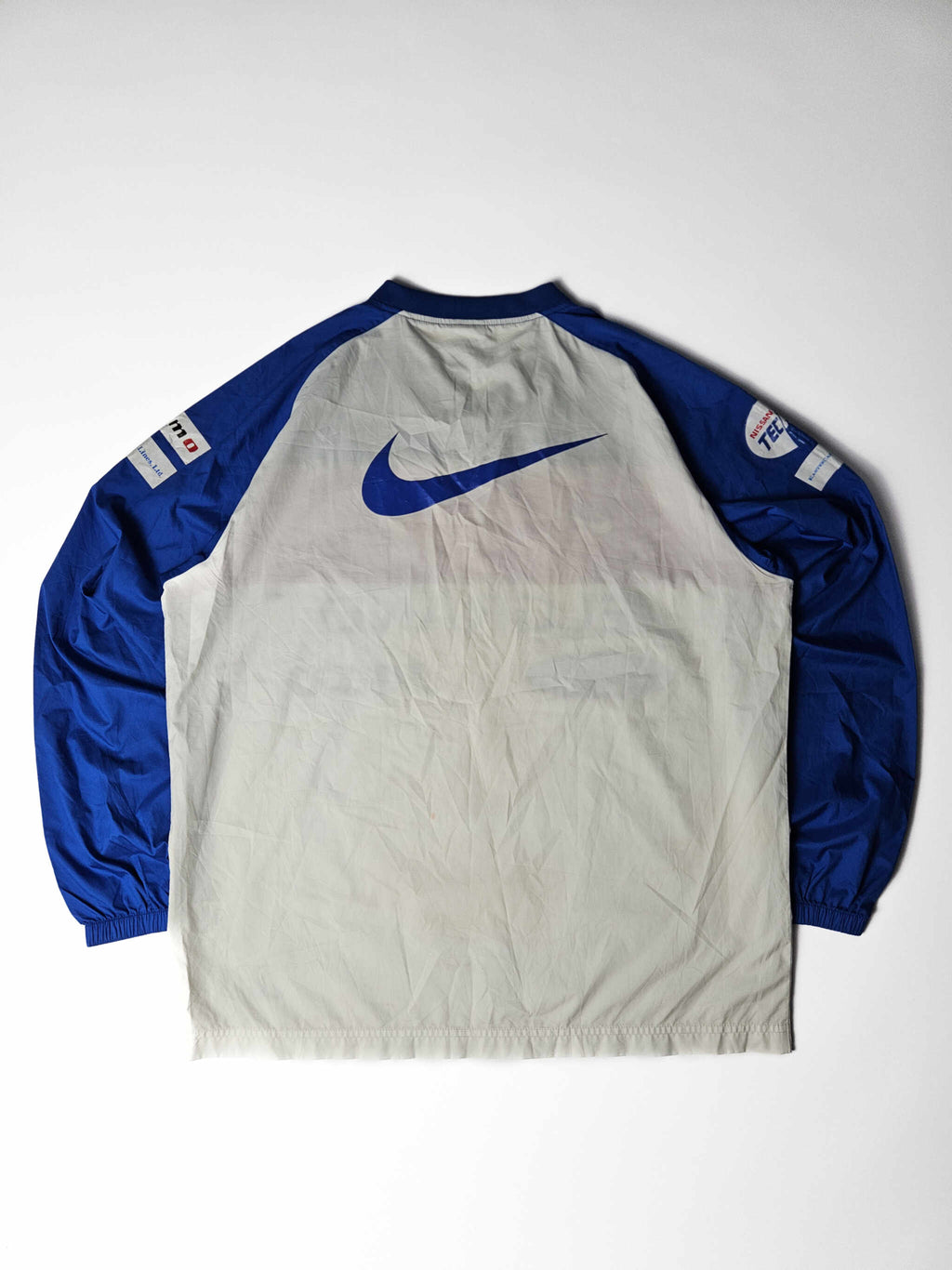 Achterzijde van een authentiek 2000s vintage Yokohama F. Marinos Nike voetbalshirt – grote blauwe Nike swoosh en originele gesponsorde mouwen, populair bij J-League verzamelaars


