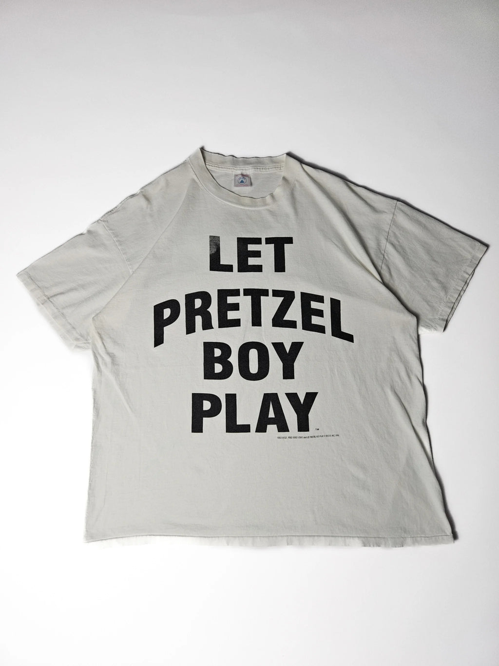 Authentiek 1996 vintage Delta Let Pretzel Boy Play T-shirt in wit met grote zwarte typografische print – single stitch Made in USA, geliefd bij streetwear en reclame T-shirt verzamelaars

