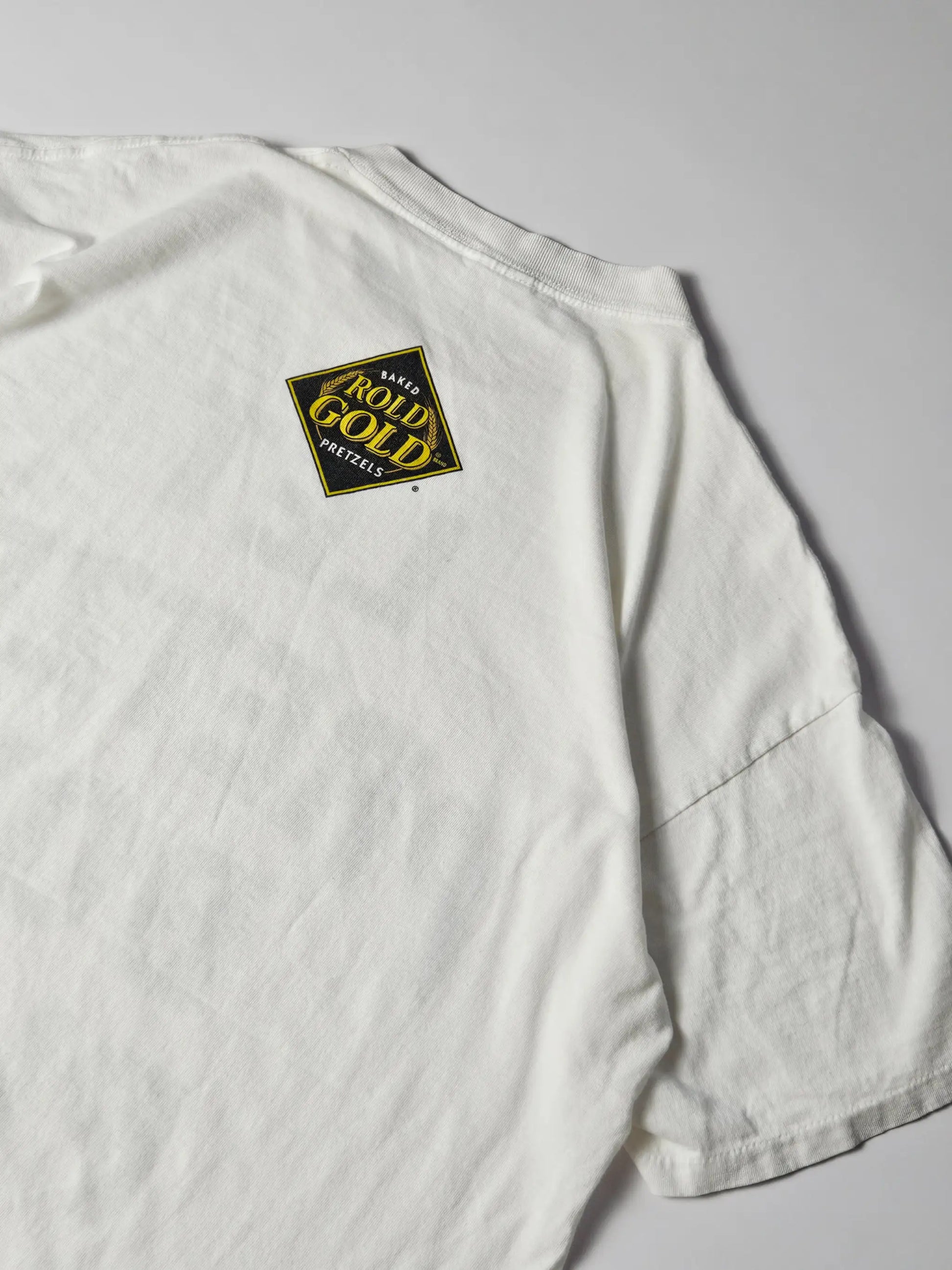Rold Gold Pretzels logo op de achterzijde – geel en zwart opdruk detail van het 1996 Delta Let Pretzel Boy Play reclame T-shirt, klassiek jaren 90 promo design

