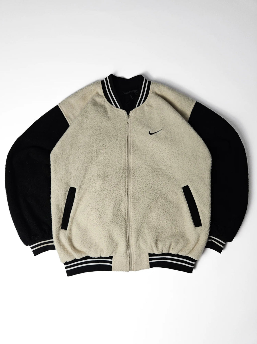 Zwart-beige Nike fleece varsity jacket met geborduurd kleine Nike swoosh op de borst – relaxed fit jaren 90 streetwear en sportstyle collectors item


