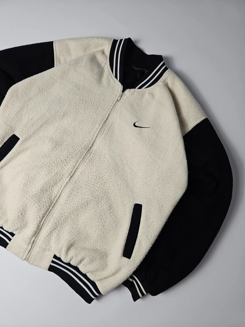 Zwart-beige Nike fleece varsity jacket met geborduurd kleine Nike swoosh op de borst – relaxed fit jaren 90 streetwear en sportstyle collectors item

