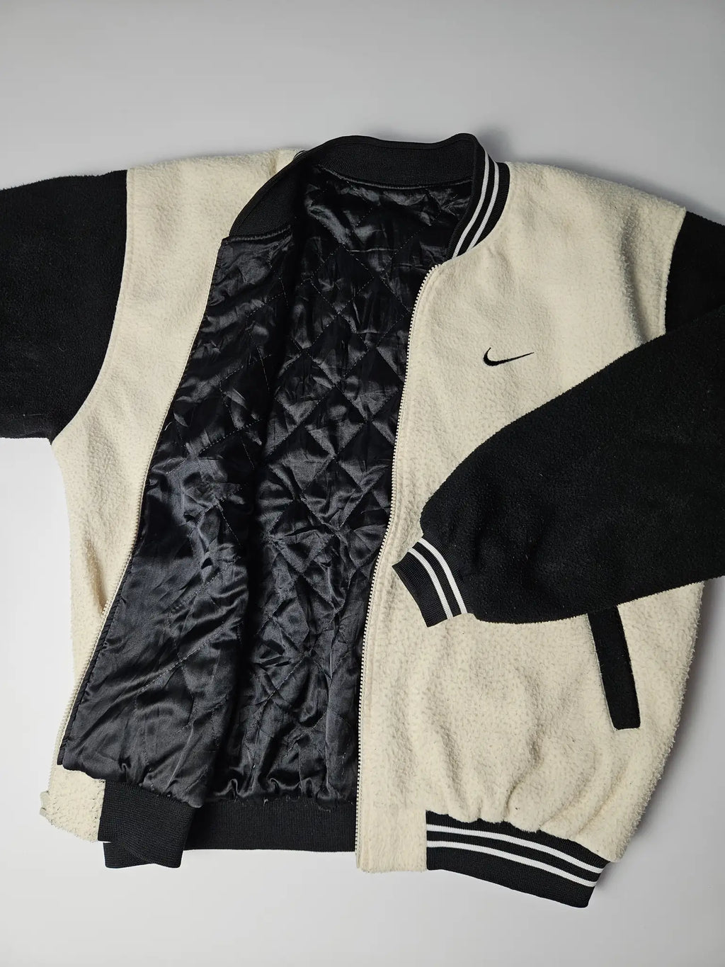 Binnenkant van Nike vintage fleece varsity jacket met gewatteerde satijnen voering – authentiek jaren 90 sport streetwear item voor retro liefhebbers

