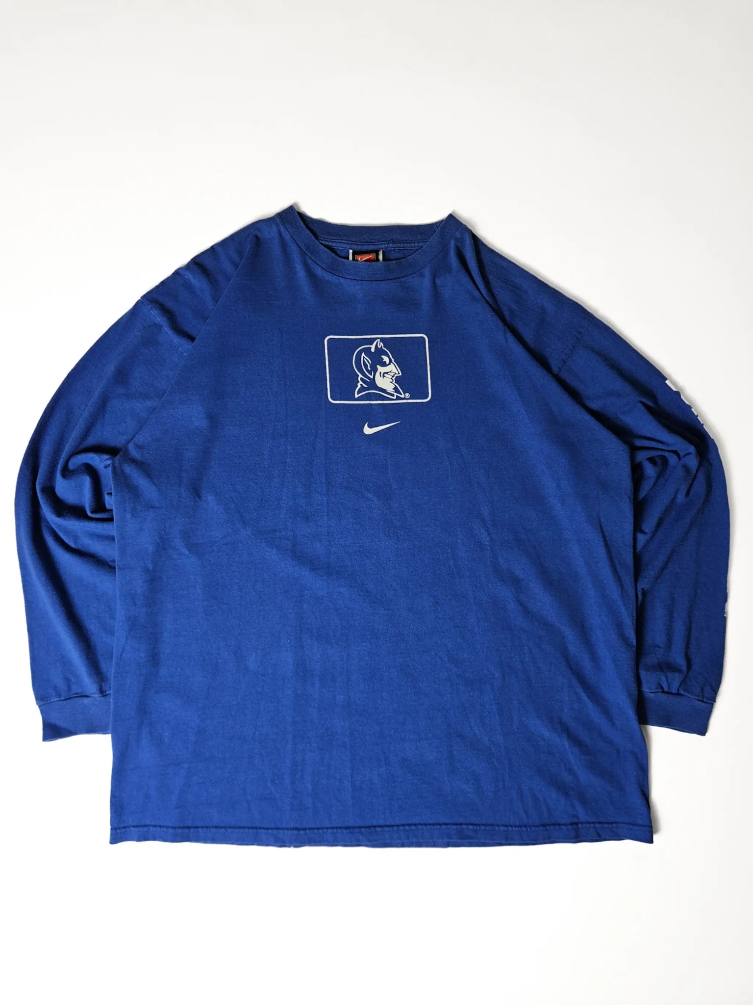 Origineel jaren 90 Nike Duke University Blue Devils long sleeve T-shirt in koningsblauw – grote Blue Devils graphic met Nike swoosh, populair bij college sports en vintage streetwear verzamelaars


