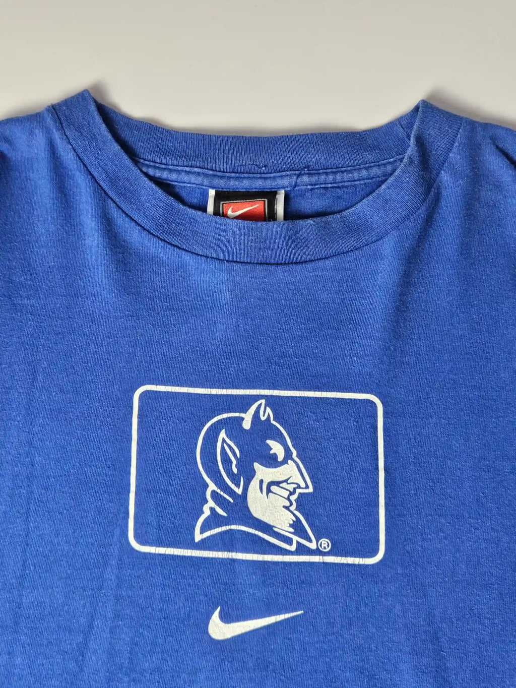 Witte Duke University sleeve print op blauw katoen – iconisch college sports design uit de jaren 90, geliefd bij American collegewear fans en sportverzamelaars

