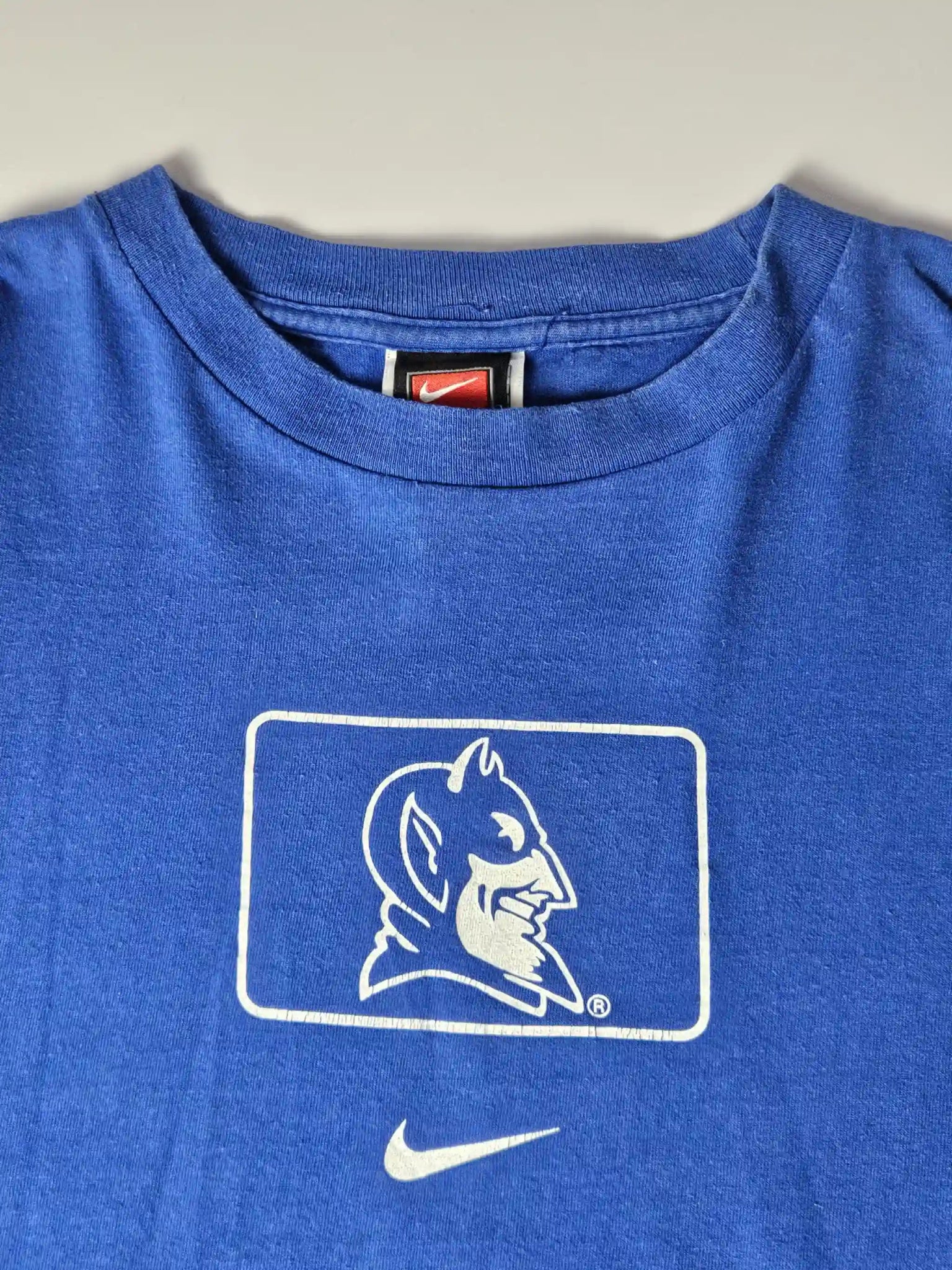 Witte Duke University sleeve print op blauw katoen – iconisch college sports design uit de jaren 90, geliefd bij American collegewear fans en sportverzamelaars


