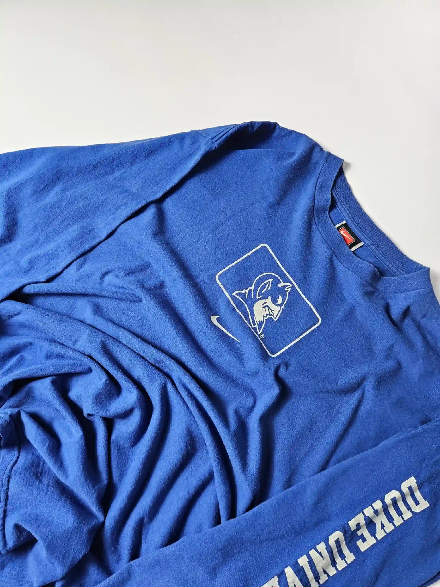 Witte Duke University sleeve print op blauw katoen – iconisch college sports design uit de jaren 90, geliefd bij American collegewear fans en sportverzamelaars

