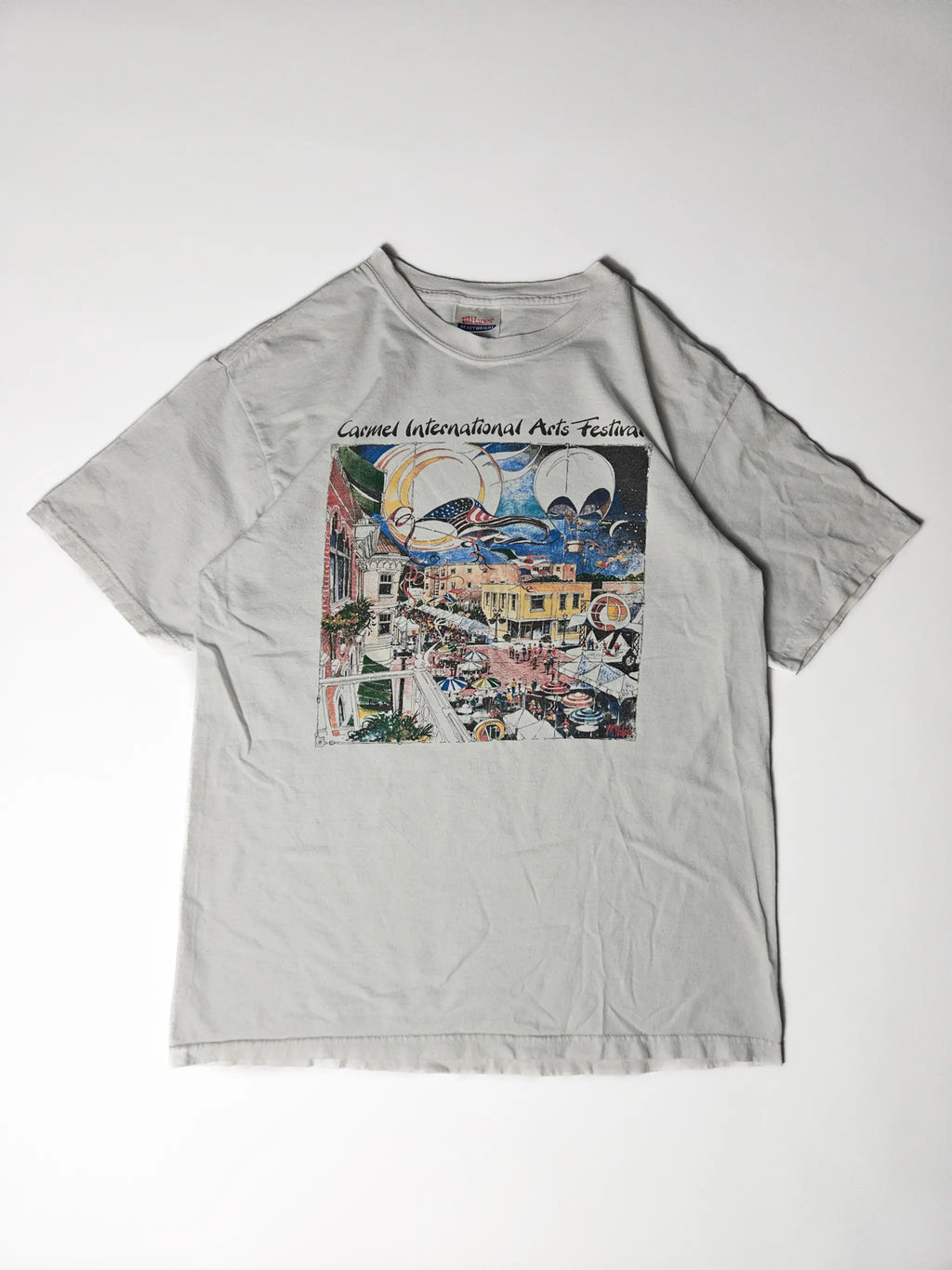 Origineel jaren 90 Hanes Heavyweight Carmel International Arts Festival T-shirt in wit – kleurrijke illustratie van festival met luchtballonnen en druk stadsplein, geliefd bij kunst- en festival T-shirt verzamelaars

