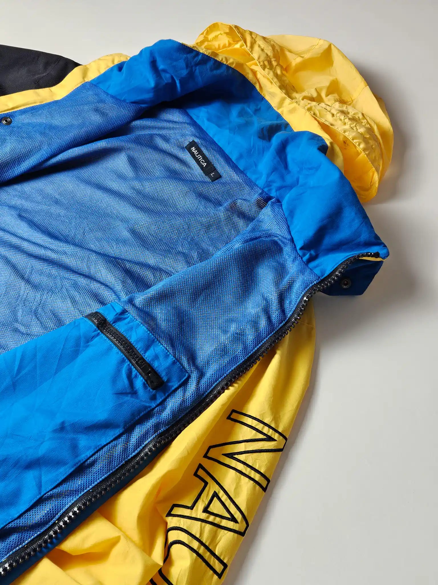 Nautica vintage sailing jacket flatlay Japan Market XL met rits open en blauwe mesh binnenkant
