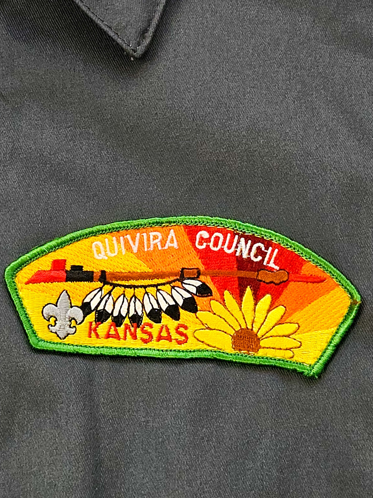 Close-up van de geborduurde Quivira Council Kansas-patch op de donkergrijze vintage workwear jas.