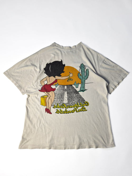 Achterkant van een ecru Betty Boop vintage T-shirt uit de jaren '90 met grote faded Route 66 backprint van Betty Boop in een Amerikaans woestijnlandschap.