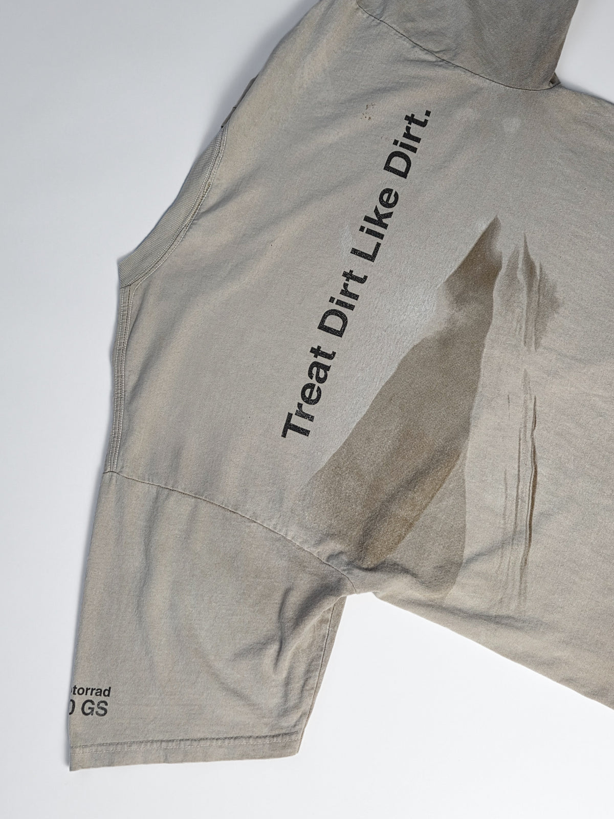 Achterkant van het zandkleurige vintage BMW Motorrad T-shirt met duinen, bandensporen en de tekst Treat Dirt Like Dirt.
