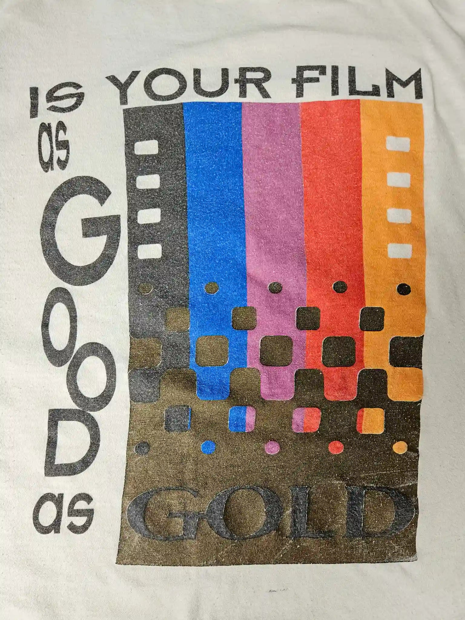 Detail: Close-up van regenboogprint en tekst "Is Your Film as Good as Gold"

