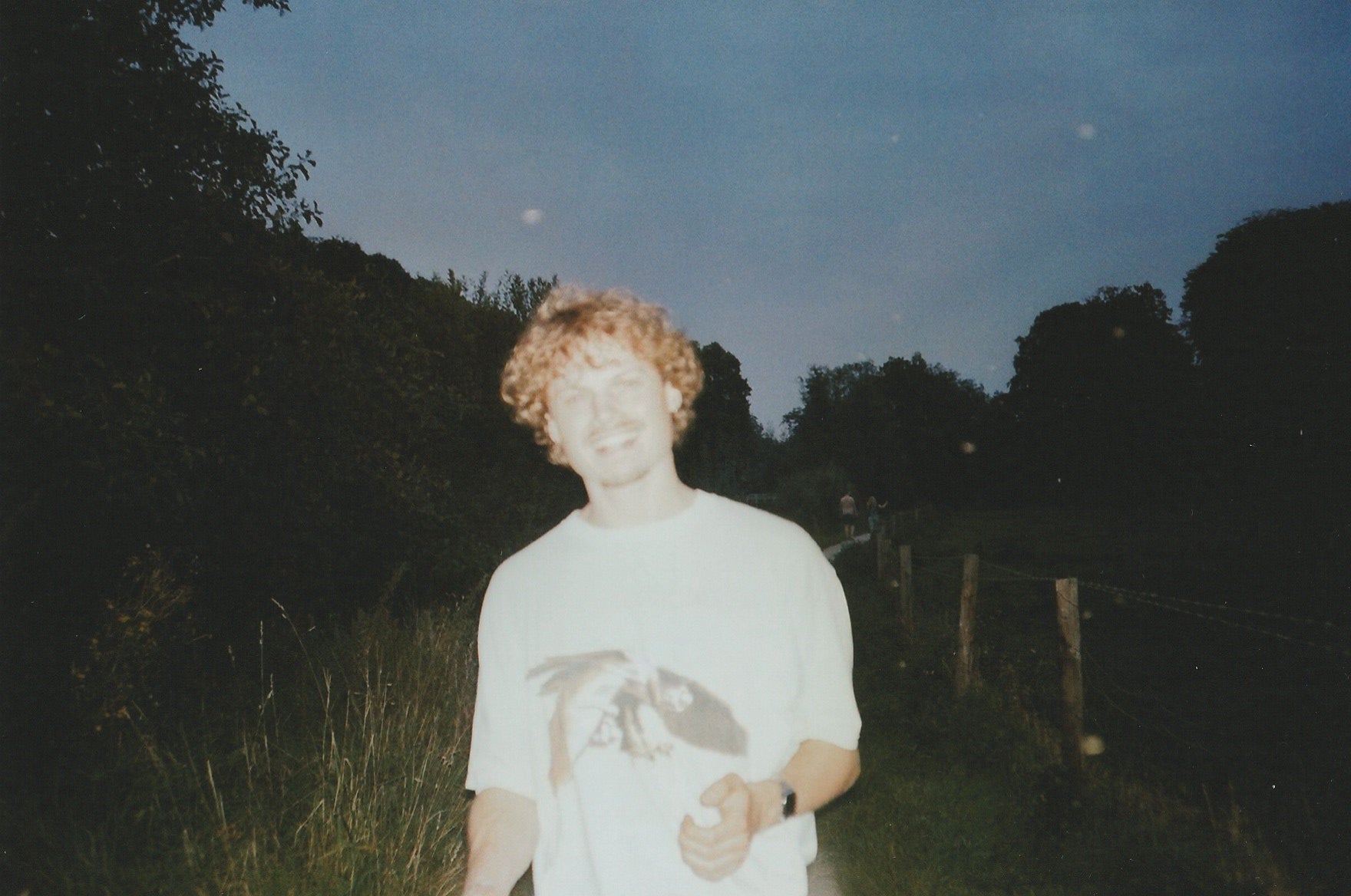 Portret van Jasper, oprichter van Slow Fashion Vintage, met vintage T-shirt. Gefotografeerd op 35mm analoge film, buiten op een zomerse avond.
