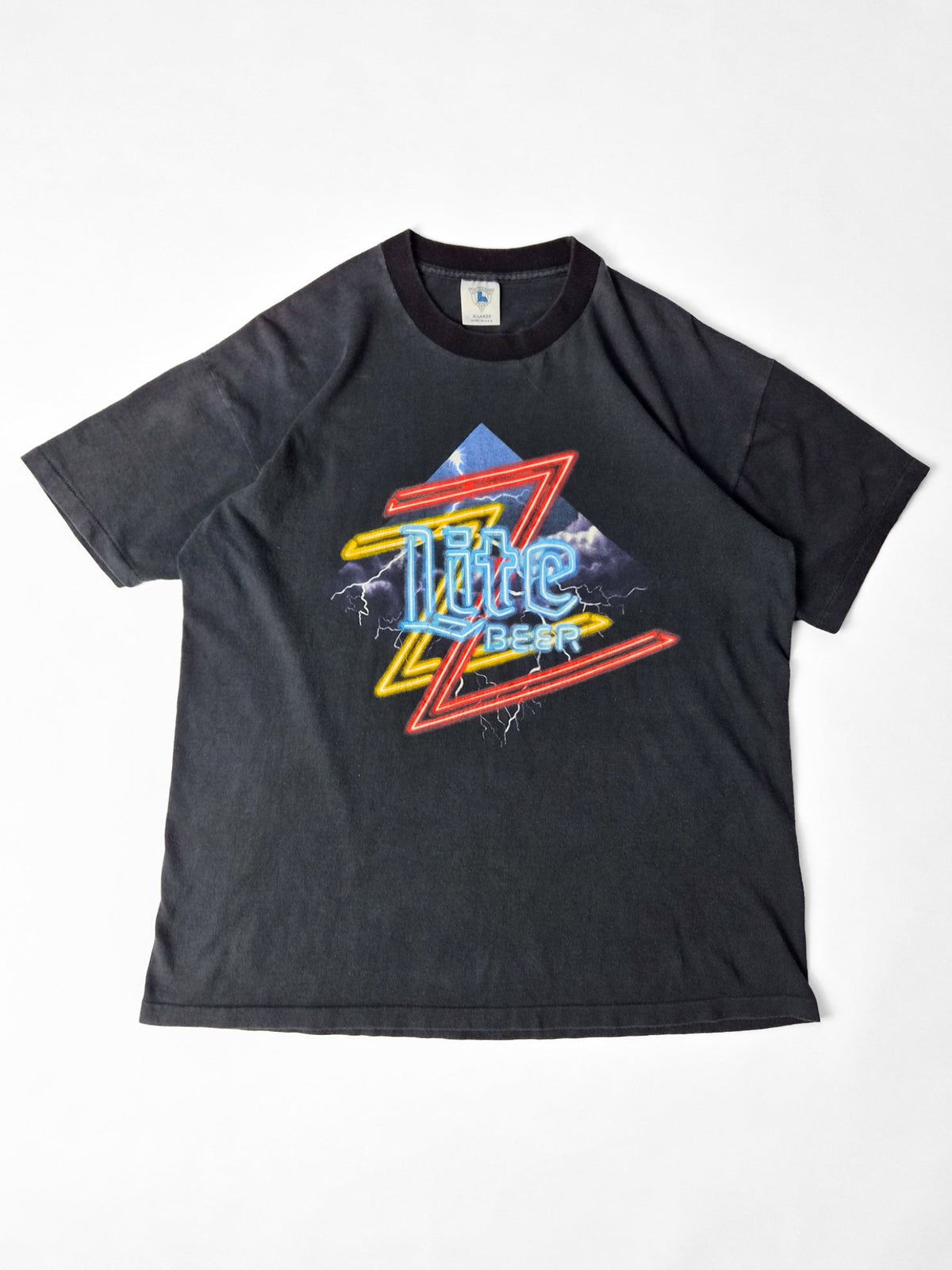 Faded zwart vintage Miller Lite T-shirt met een kleurrijke ZZ Top-neonprint en bliksemschichten op de voorkant.