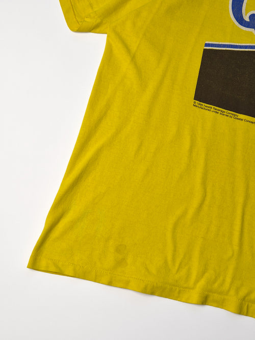 Detail van geel vintage Nestlé Quik T-shirt uit 1996 met klein vlekje linksonder op de voorkant.