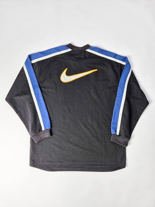 Achterkant van de Nike sweater met een grote witte stoffen Swoosh en oranje borduurwerk.