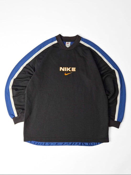 Zwarte vintage Nike sweater met Nike-naam, oranje Swoosh en blauw-witte banen over de schouders en mouwen.