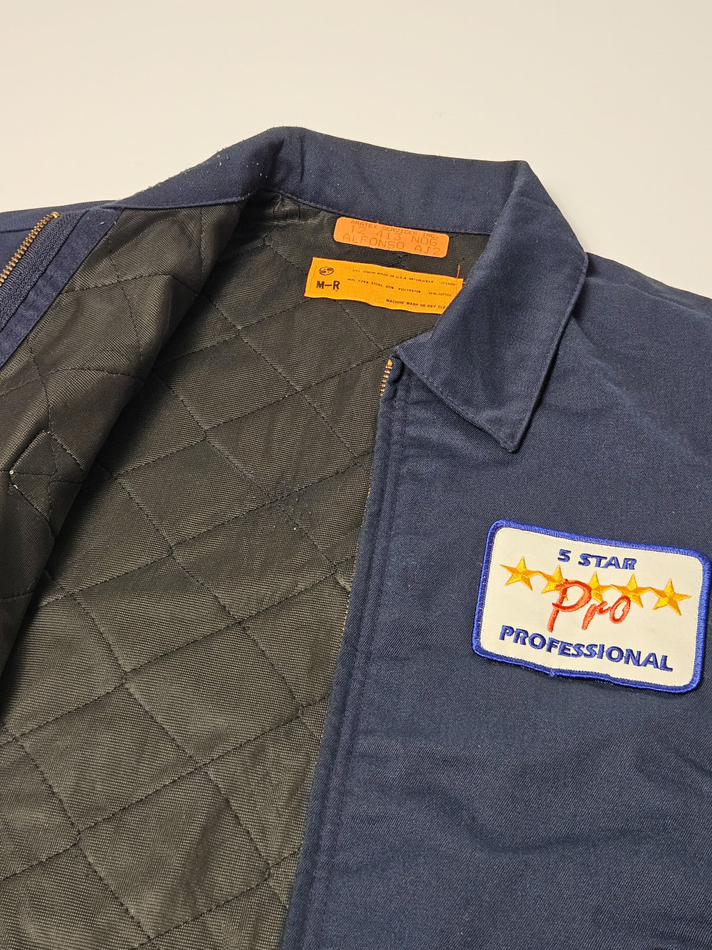 Close-up van geborduurde 5 Star Pro patch en binnenkant quilted op vintage jas
