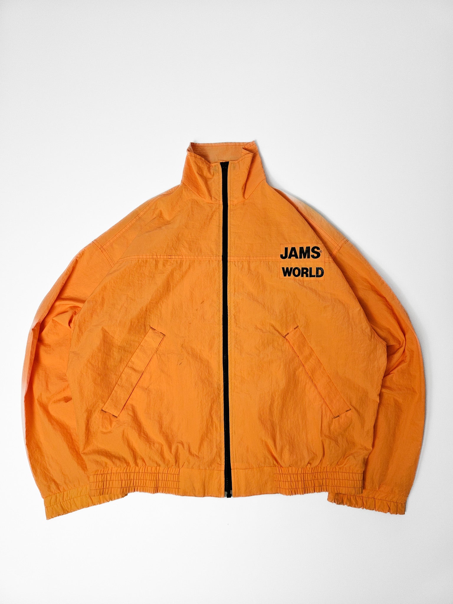 Oranje vintage Jams World windbreaker met zwarte borstprint en ritssluiting, uit de jaren 90