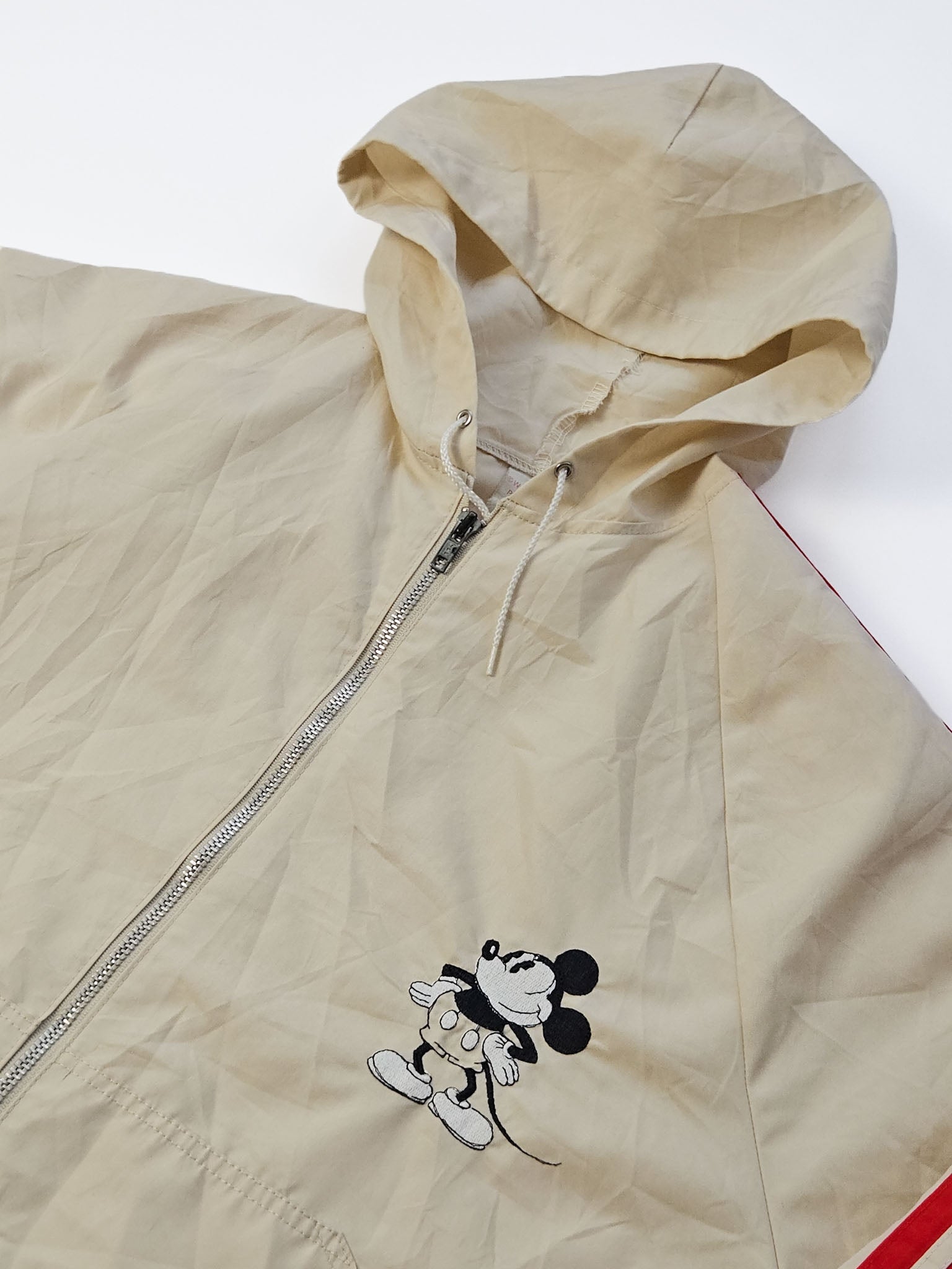 Close-up geborduurde klassieke Mickey Mouse in rubber hose-stijl op roomwitte shell