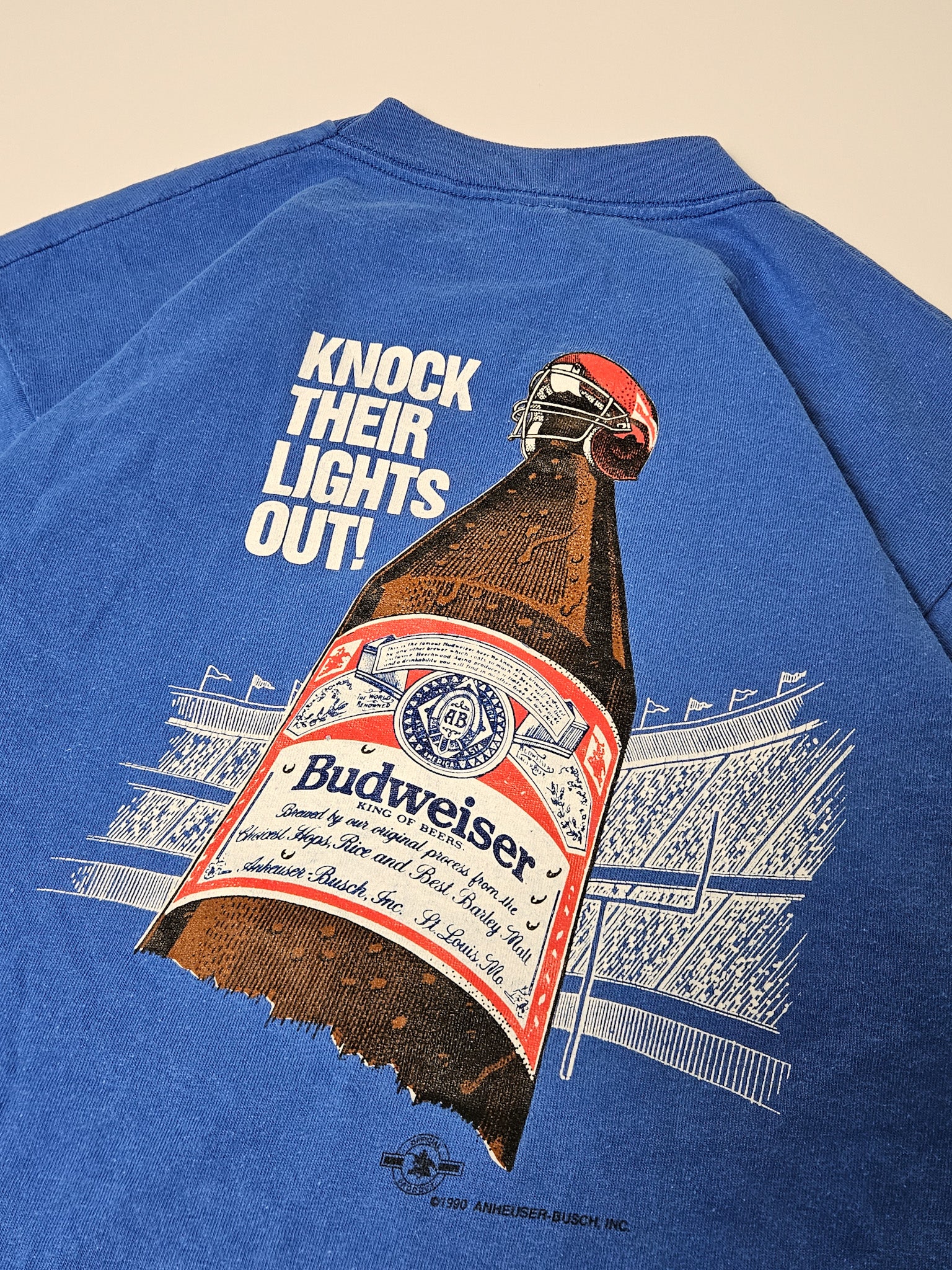 Close-up van de Budweiser "Know Their Lights Out" print op vintage Bud Bowl T-shirt