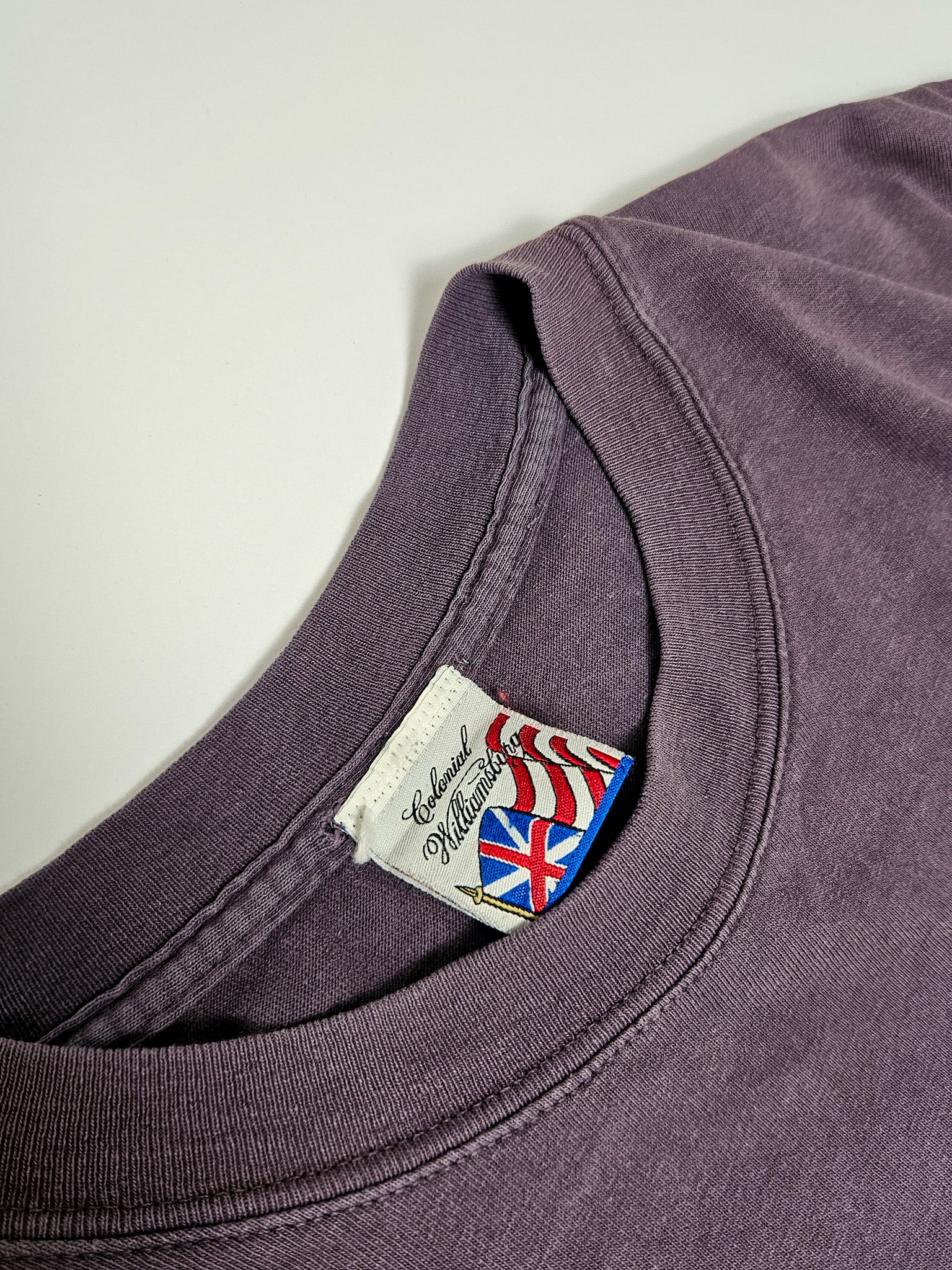 Wit neklabel met Amerikaanse en Britse vlag en merknaam "Colonial Williamsburg"
