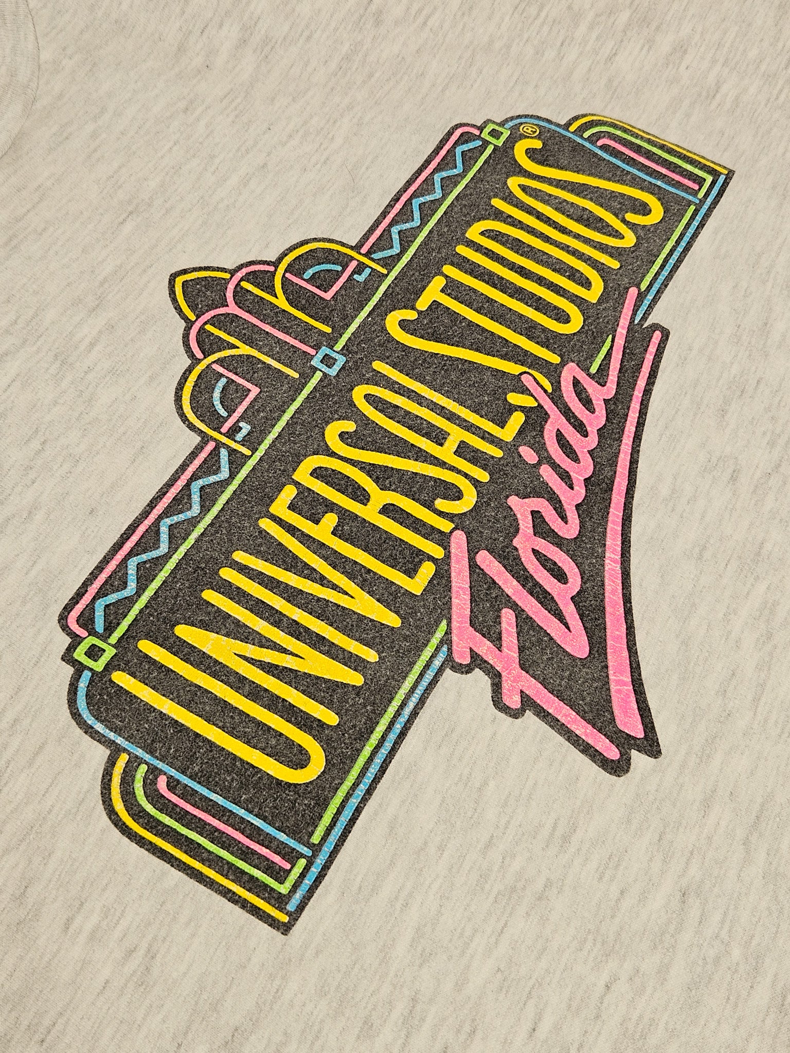 Close-up van neonkleurige Universal Studios Florida logo met art deco lijnen
