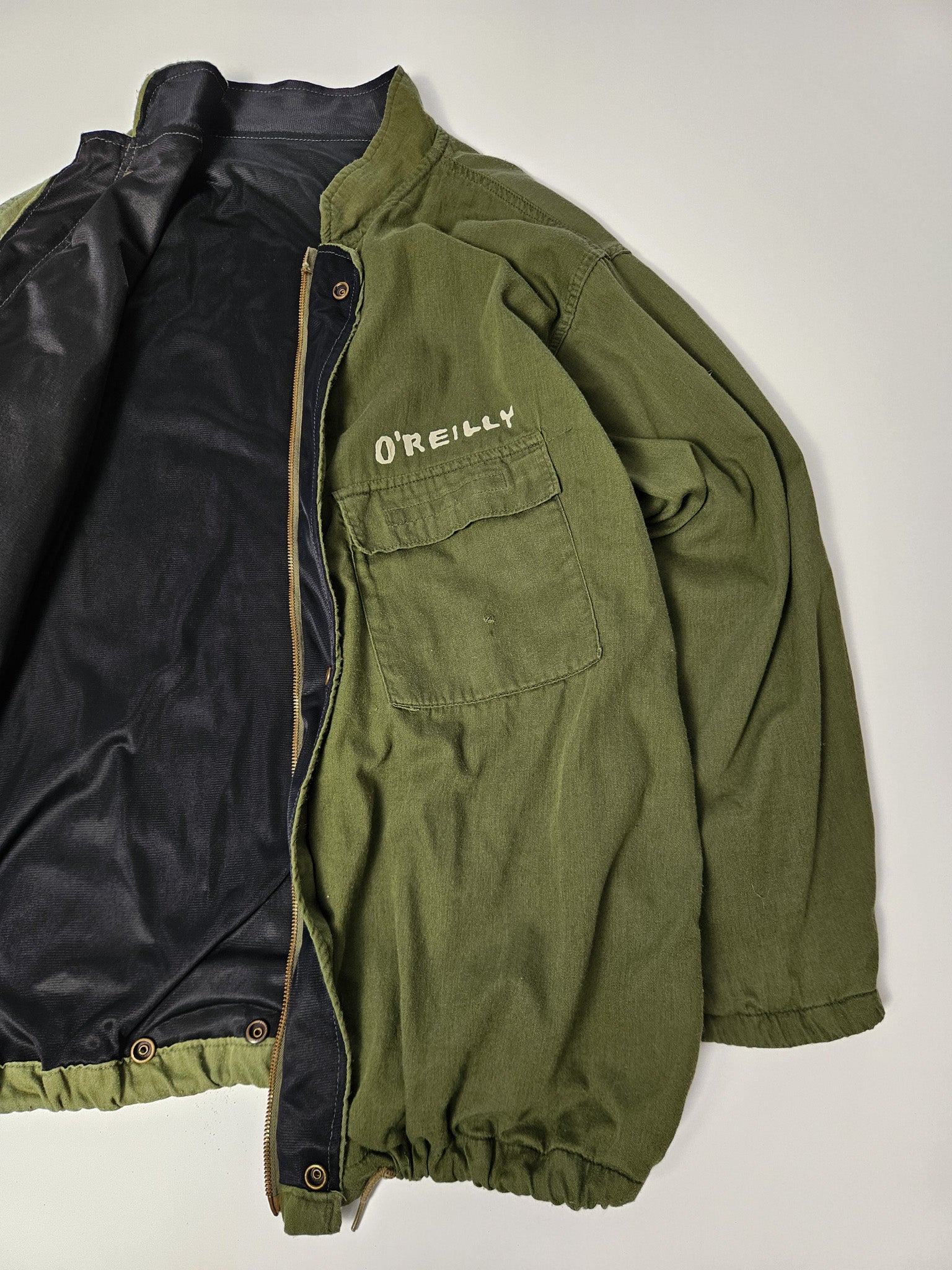 Flatlay van de vintage MASH field jacket met army styling, borstpatch en klassieke schouderepauletten*

