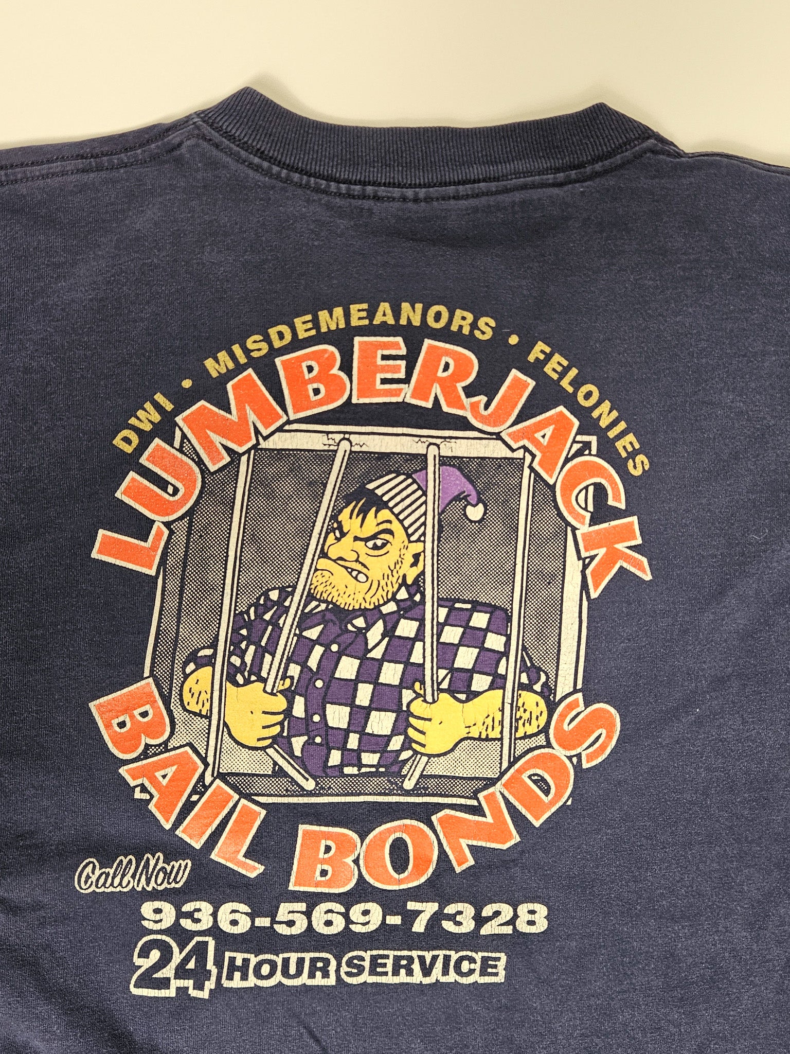 Close-up van de Lumberjack Bail Bonds print op vintage T-shirt met cartoon en telefoonnummer