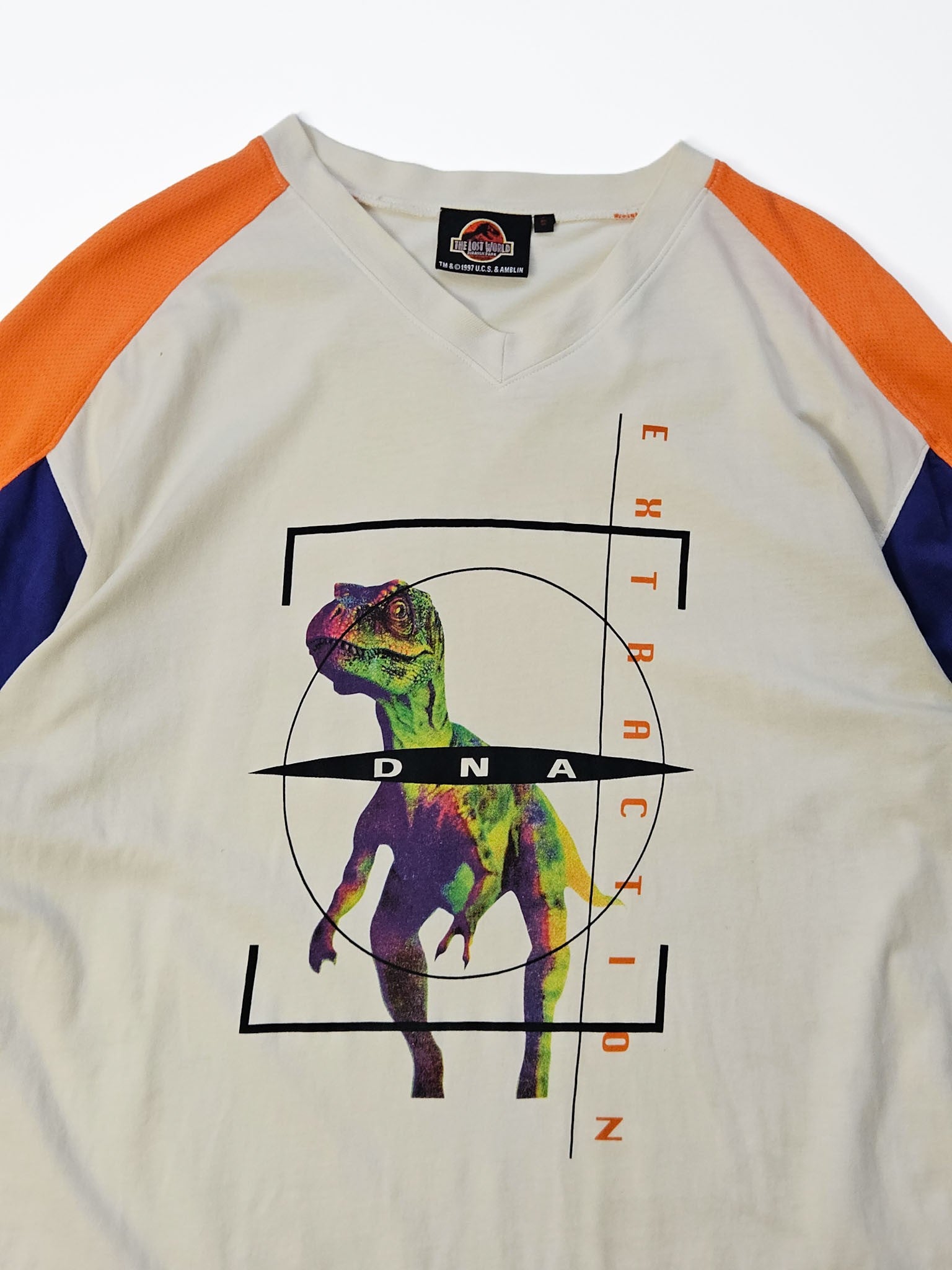 1997 The Lost World Jurassic Park vintage jersey tee in gebroken wit met oranje en blauwe colour blocking en DNA Extraction raptor print, voorkant flatlay